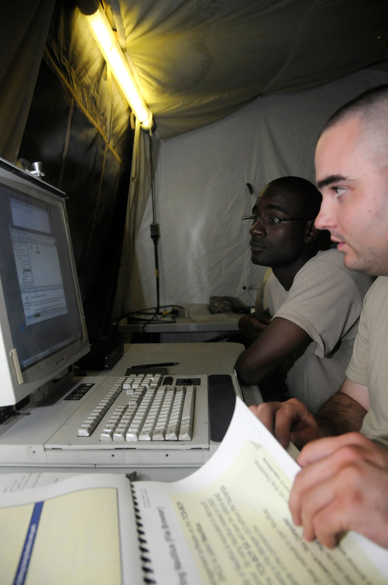 Spc. Wayne Landry (front) and Sgt. Eric Simpson (back), both early system warning operators assigned to Delta 2.43, review training guides and input data into the force operations battery command post so they can complete their post deployment build 6 upgrade training Sept. 8, 2008. The Army Patriot battery is responsible for providing missile defense at this undisclosed air base in Southwest Asia. Specialist Landry, a native of Frederick, Md., and Sergeant Simpson, a native of San Francisco, Calif., are both deployed from Fort Bliss, Texas, in support of Operations Iraqi Freedom, Enduring Freedom and Joint Task Force-Horn of Africa. (U.S. Air Force photo by Staff Sgt. Darnell T. Cannady/Released)
