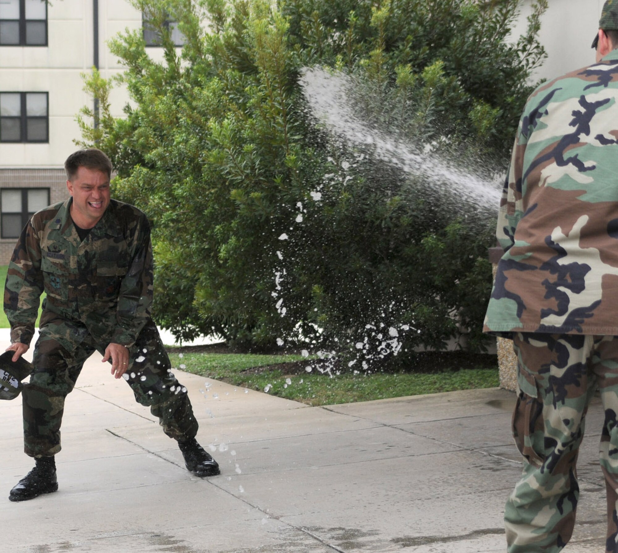 Lt. Col. Jeff Szatanek, outgoing commander, gets a farewell hose-down from 2nd Lt. Phil Hinson.  Colonel Szatanek’s new assignment is deputy division chief of civil engineering programs for Headquarters Air Force District, Washington, D.C.  (U.S. Air Force photo by Kemberly Groue)
