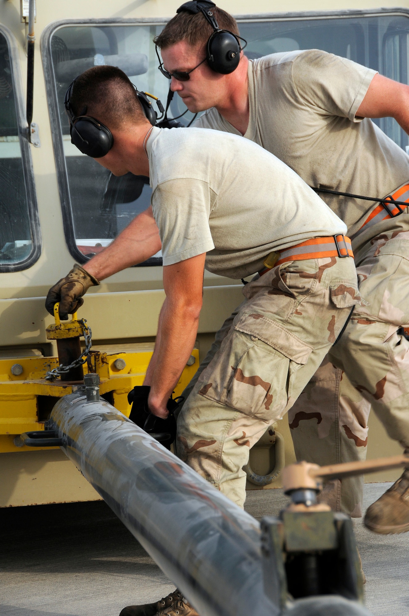 Staff Sgt. Scott Shipman, tow supervisor, drops the locking pin in place connecting a tow vehicle with a B-1 Lancer via the tow bar held in place by Airman 1st Class Brian Decker, Sept. 9, 2008.   The tow vehicle will be used to back the B-1 into a parking space on the ramp at this undisclosed air base in Southwest Asia. The B-1 is called upon daily to support ground forces engaged in both Operations Iraqi and Enduring Freedom.  It carries the largest payload of both guided and unguided weapons in the Air Force inventory and is the backbone of America's long-range bomber force. It can rapidly deliver massive quantities of precision and non-precision weapons against any adversary, anywhere in the world, at any time. Sergeant Shipman is a native of Medina, Texas, and Airman Decker hails from Murphy, N.C. Both are assigned to the 379th Expeditionary Aircraft Maintenance Squadron, 34th Aircraft Maintenance Unit, and are deployed from Ellsworth Air Force Base, S.D. (U.S. Air Force photo by Tech. Sgt. Michael Boquette/Released)