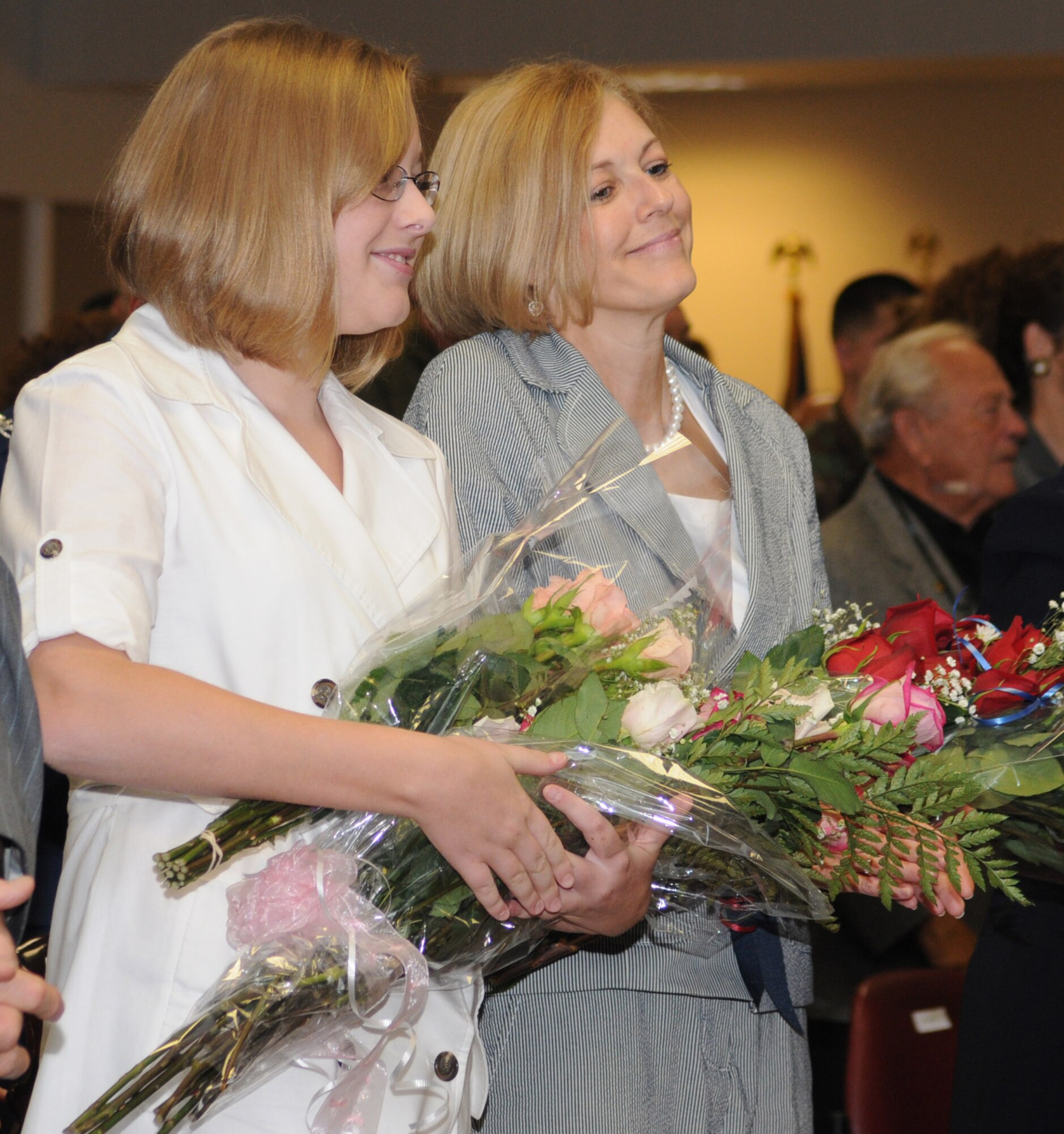 Kate and Charlene Touhill receive bouquets of roses from General Touhill.  Kate is a sophomore at Biloxi High School.  The Touhills’ son, Andrew, attends the University of Illinois.  General Touhill’s parents were unable to make the trip because of the hurricane threat.  (U.S. Air Force photo by Kemberly Groue)