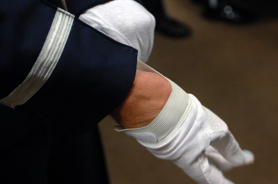 An Honor Guard member prepares for practice by adding the last piece of clothing that makes up the Honor Guard service uniform during a weekly practice Sept. 3, 2008.  The main goal of the Team Mildenhall Honor Guard is to honor fallen veterans and uphold the congressional mandate that warrants full military honors to service members who pass away. (U.S. Air Force photo by Senior Airman Teresa M. Hawkins)