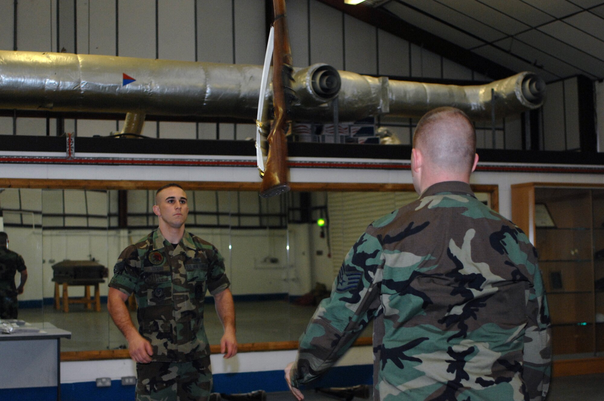 Senior Airman Joshua Lucero, left, 352nd Maintenance Squadron, prepares to catch a rifle tossed by Staff Sgt. Michael Majors, 352nd Maintenance Squadron, during Team Mildenhall Honor Guard practice Sept. 3, 2008. (U.S. Air Force photo by Senior Airman Teresa M. Hawkins)
