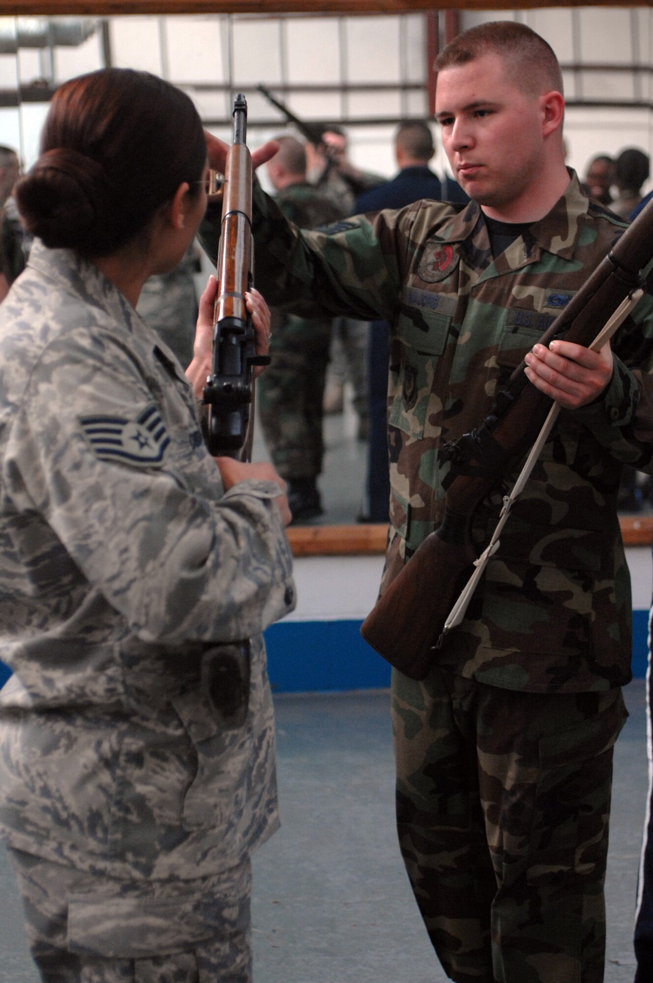 Staff Sgt. Michael Majors, 352nd Maintenance Squadron, instructs Staff Sgt. Nicole Didasa, 352nd Operations Squadron, how to properly perform as part of a firing party during their weekly practice Sept. 3, 2008. The main goal of the Team Mildenhall Honor Guard is to honor fallen veterans and uphold the congressional mandate that warrants full military honors to servicemembers who pass away. The honor guard also honors those who retire, posts colors for changes of command and participates in parades and special events. (U.S. Air Force photo by Senior Airman Teresa M. Hawkins)