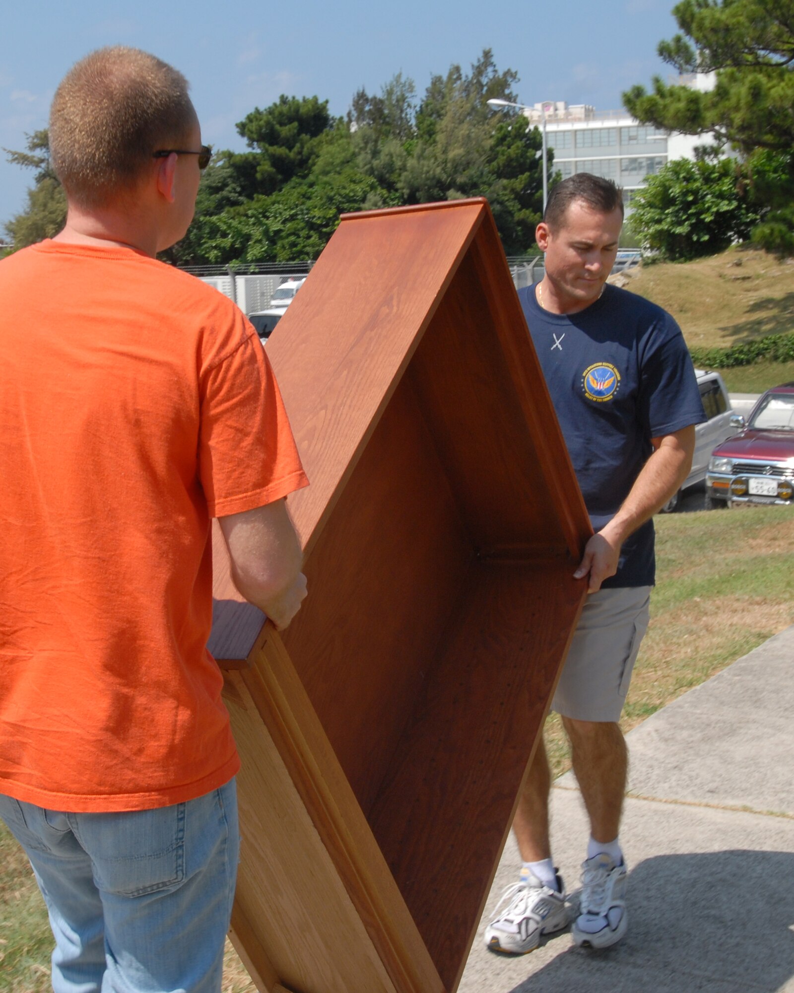 Tech. Sgt.  Bryan Herrington, 18 Operations Support Squadron, and Capt Jon Quinlan, 961 Airborne Air Control Squadron from Kadena Air Base, volunteer to help move furniture for the Storks Nest renovation project at Camp Lester. (U.S. Air Force photo/Staff Sgt Angelique Perez)
