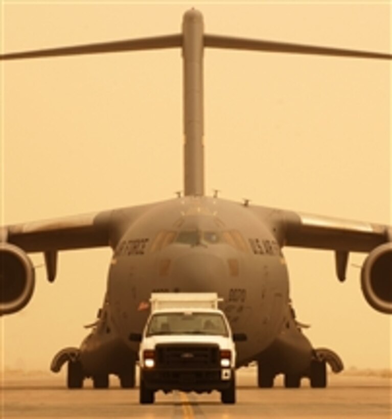 A C-17 Globemaster III aircraft from Charleston Air Force Base, S.C., follows a transient truck to a parking ramp after landing at Joint Base Balad, Iraq, during a sandstorm on Sept. 8, 2008.  