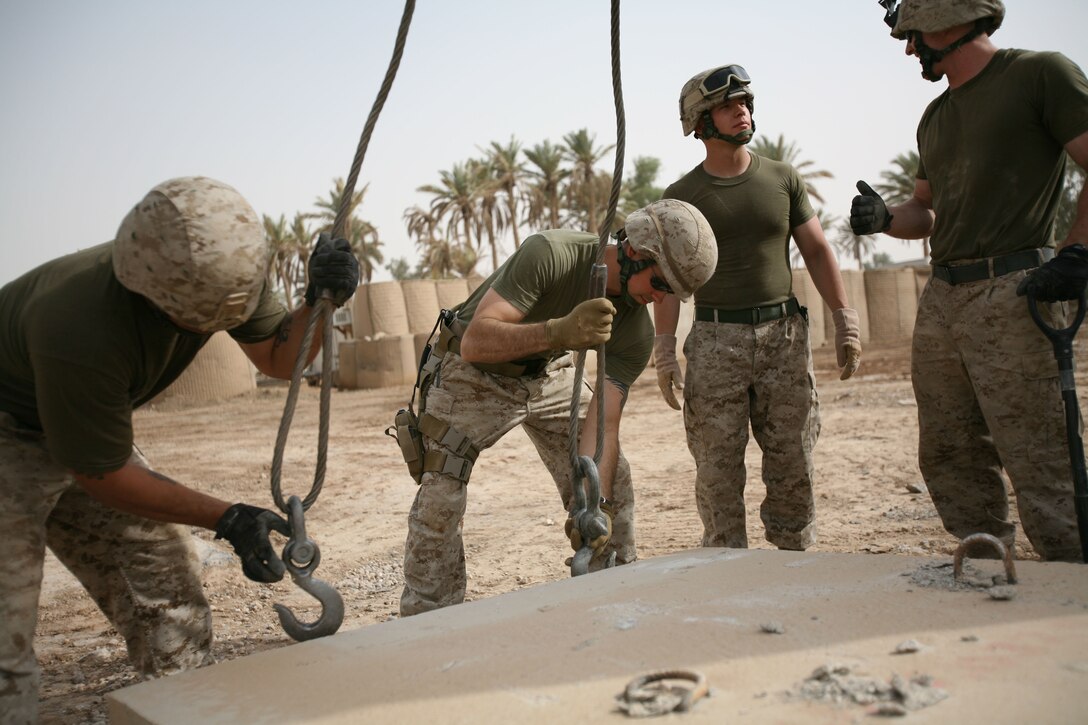 Gunnery Sgt. Christopher L. Hambaugh, the Regimental Combat Team 1 Motor Transportation chief from Tampa, Fla., levels ground below a barrier at Camp Ramadi, Iraq, Sept. 22. Marines adapted quickly after their move to the camp, making it a home away from home. They plan to leave it better than they found it. (Official U.S. Marine Corps photo by Cpl. Stephen McGinnis) (Released)