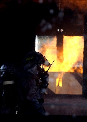 MISAWA AIR BASE, Japan -- Staff Sgt. Daniel Ormsby, 35th Civil Engineering Squadron firefighter, radios information back to a control tower from inside a burning aircraft during a simulated crash here Sept. 10. The training is conducted in order to acquaint Towada City fire fighters with Air Force training in case of crash off base. (U.S. Air Force photo by Senior Airman Chad Strohmeyer) 