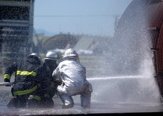 MISAWA AIR BASE, Japan -- Shuji Imota, 35th Civil Engineering Squadron, firefighter crew chief, instructs Towada City firefighters on how to extinguish a burning aircraft during a simulated crash here Sept. 10. The training was conducted in order to acquaint Towada City firefighters with Air Force training in case of a crash off base. (U.S. Air Force photo by Senior Airman Chad Strohmeyer) 