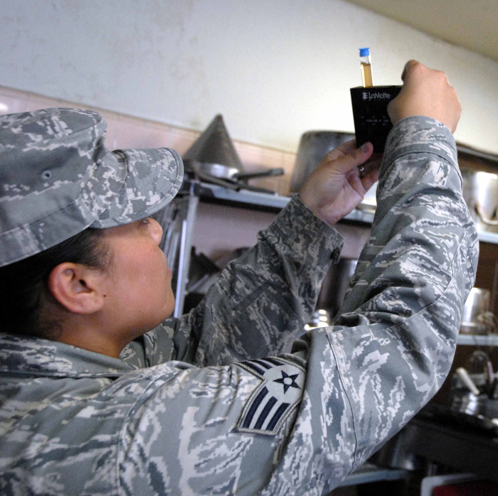 OSAN AIR BASE, Republic of Korea -- Senior Airman Verna Munoz, 51st Aerospace Medicine Squadron Bioenvironmental Engineering technician, compares water samples taken at the Challenger Club. (U.S. Air Force photo/Staff Sgt. Candy Knight)