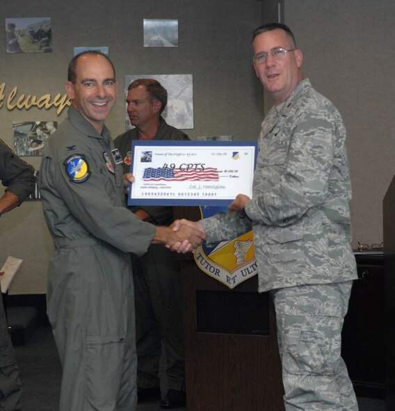 Maj. Steven Raudman receives a check on behalf of the 49th Comptroller Squadron from Col. Jeff Harrigian, 49th Fighter Wing commander, at the 49 FW Headquarters building at Holloman Air Force Base, N.M., Sept. 10. The 49 CPTS received a check for $1,000 to use for quality of life initiatives within the squadron for placing 2nd of the small squadrons in the Battle of Squadrons. (U.S. Air Force photo/Airman Sondra Escutia)