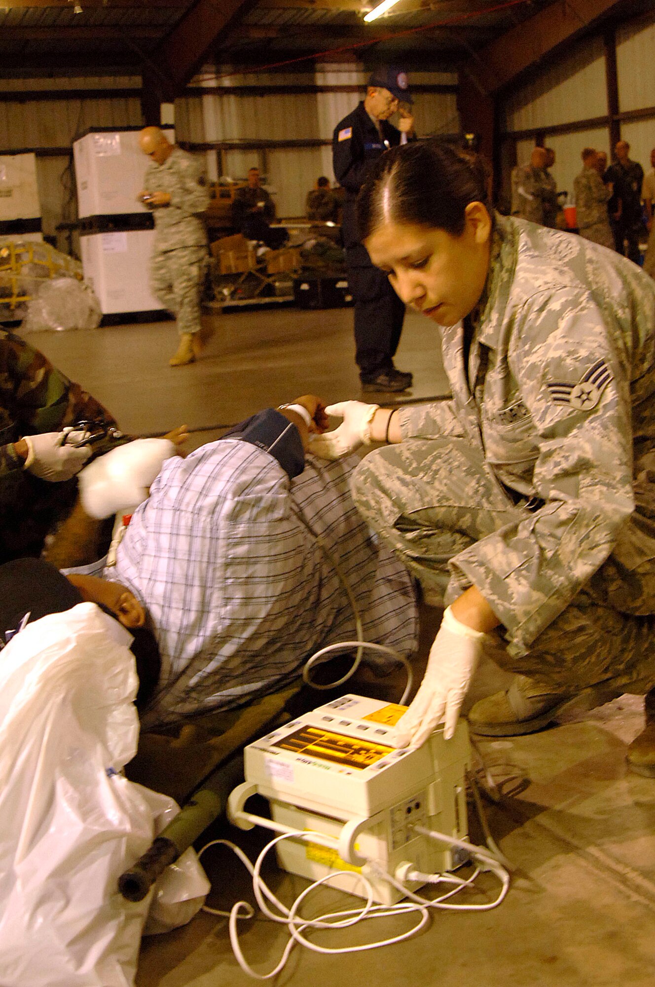 Senior Airman Andrea Moore tends to a patient waiting for evacuation in Corpus Christi, Texas, Sept. 11. The team is helping to evacuate patients from a local area hospital. Air Force aircraft transported patients to safe locations out of Hurricane Ike's path. Airman Moore is a medical technician with a mobile aeromedical staging facility team from MacDill Air Force Base, Fla. (U.S. Air Force photo/Staff Sgt. Robert Maki)