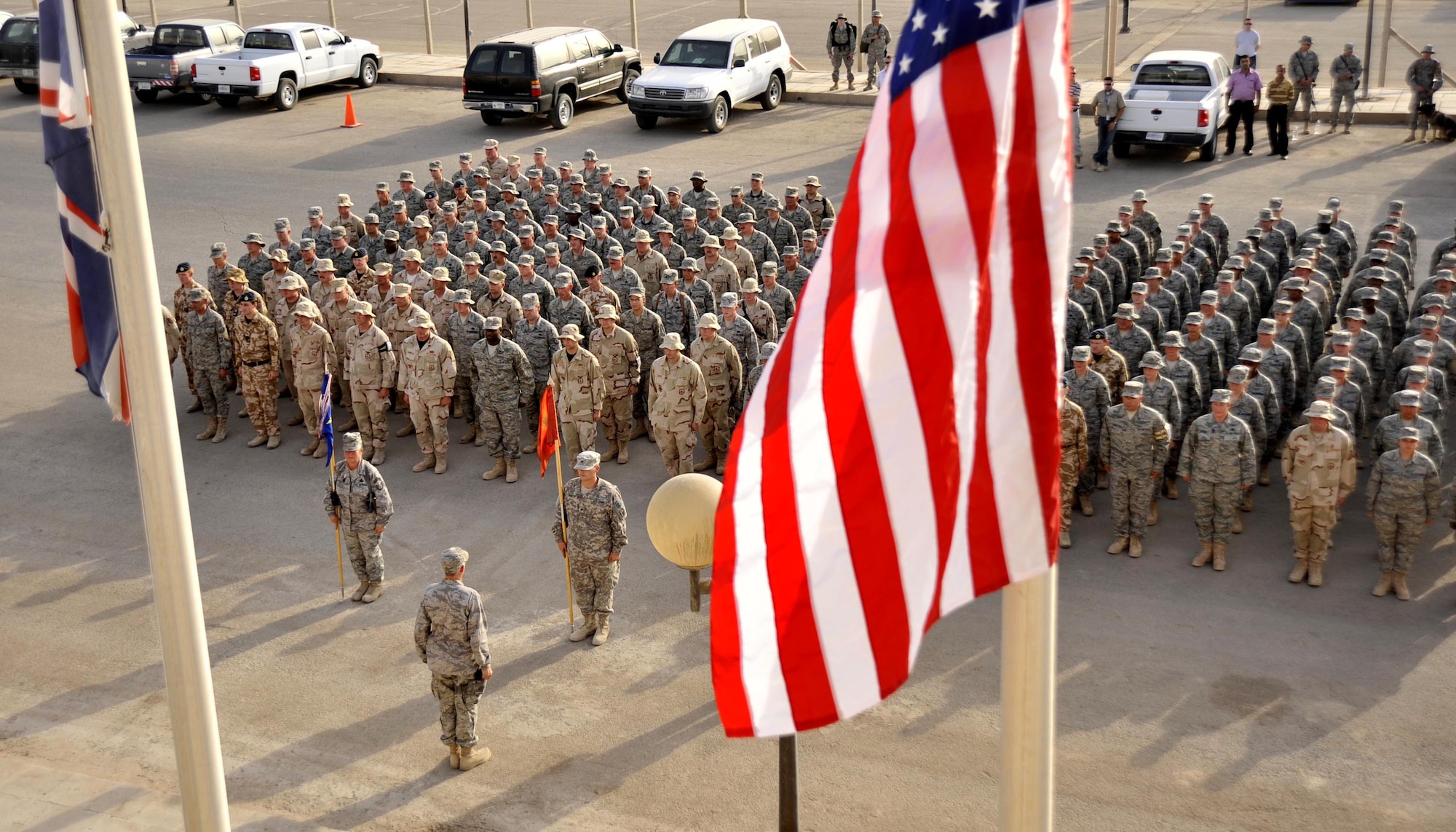 Soldiers, Airmen and Royal Air Force members stand in a joint formation for a ceremony on the seven-year anniversary of the terrorist attacks of Sept. 11, 2001, Sept. 11 at Sather Air Base, Iraq. (U.S. Air Force photo/Master Sgt. Brian Davidson)