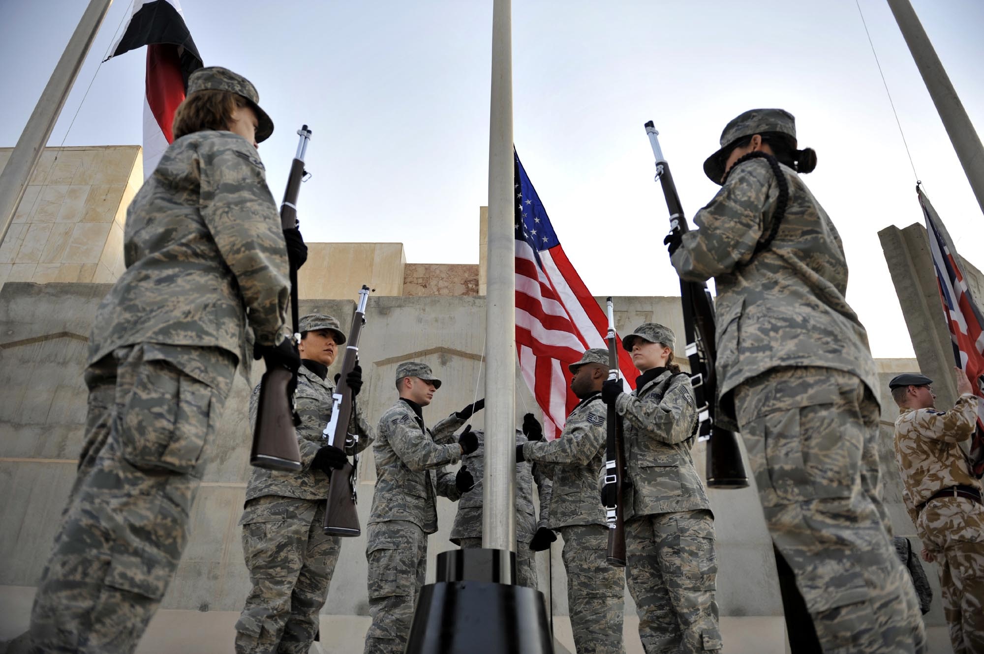 Members of the honor guard raise the flag in an early-morning ceremony on the seven-year anniversary of the terrorist attacks of Sept. 11, 2001, before lowering it to half-mast in memory of those who lost their lives Sept. 11 at Sather Air Base, Iraq. (U.S. Air Force photo/Master Sgt. Brian Davidson) 
