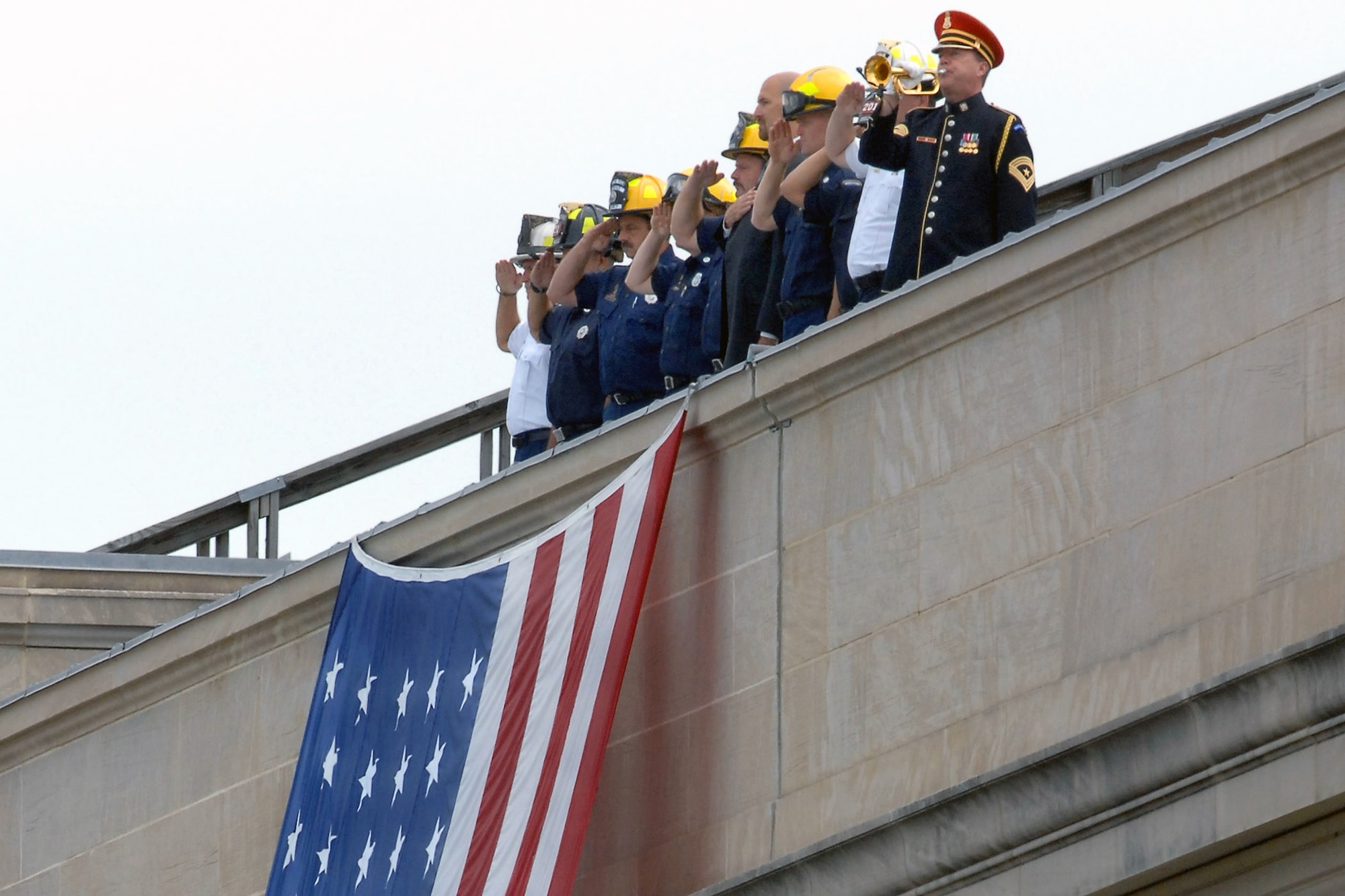 First responders stand atop the Pentagon during the Pentagon Memorial dedication ceremony Sept. 11 at Alexandria, Va. They stood at the spot where American Airlines Flight 77 crashed into the building on Sept. 11, 2001, killing 59 people aboard the flight and 125 in the building. First responders are the firefighters, police officers and other rescue workers who were first on the scene that day. (Defense Department photo/Andy Morataya)