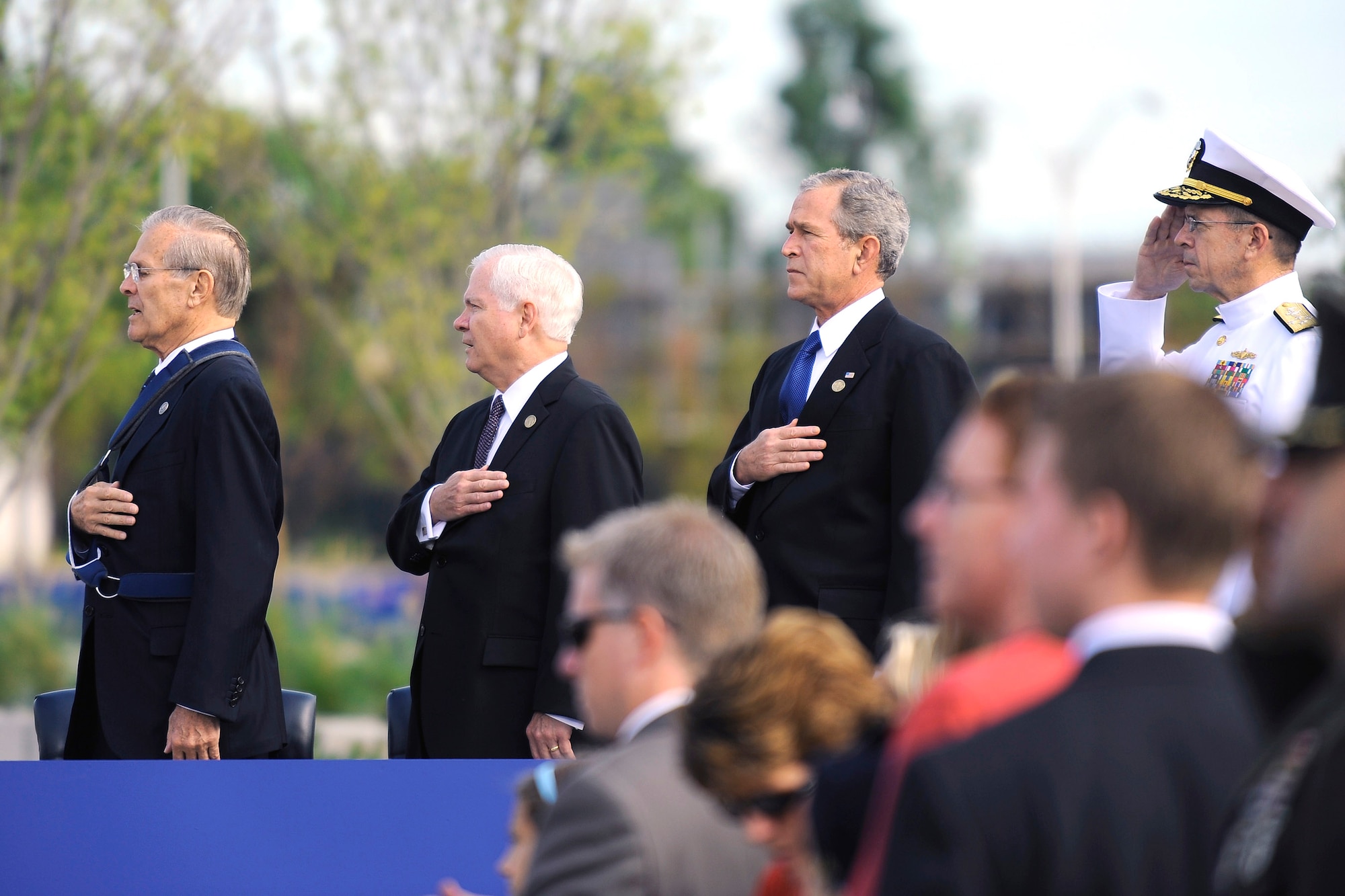 President George W. Bush, Secretary of Defense Robert M. Gates and former Secretary of Defense Donald Rumsfeld stand as the national anthem plays at the Pentagon Memorial dedication ceremony Sept. 11 at Alexandria, Va. The national memorial is the first to be dedicated to those killed at the Pentagon on Sept. 11, 2001. The site contains 184 inscribed memorial units honoring the 59 people aboard American Airlines Flight 77 and the 125 in the building who lost their lives that day. (Defense Department photo/Tech. Sgt. Jerry Morrison)