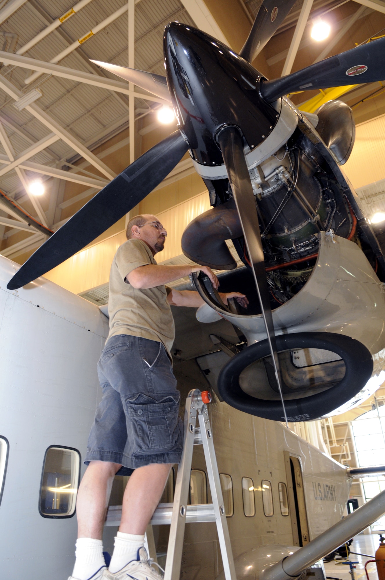 Joel Wlodarczyk, aircraft mechanic, lowers the cowling from the engine of a C-23 Sherpa to do maintenance and get it ready for the possibility of a mission to provide hurricane support. U. S. Air Force photo by Sue Sapp
