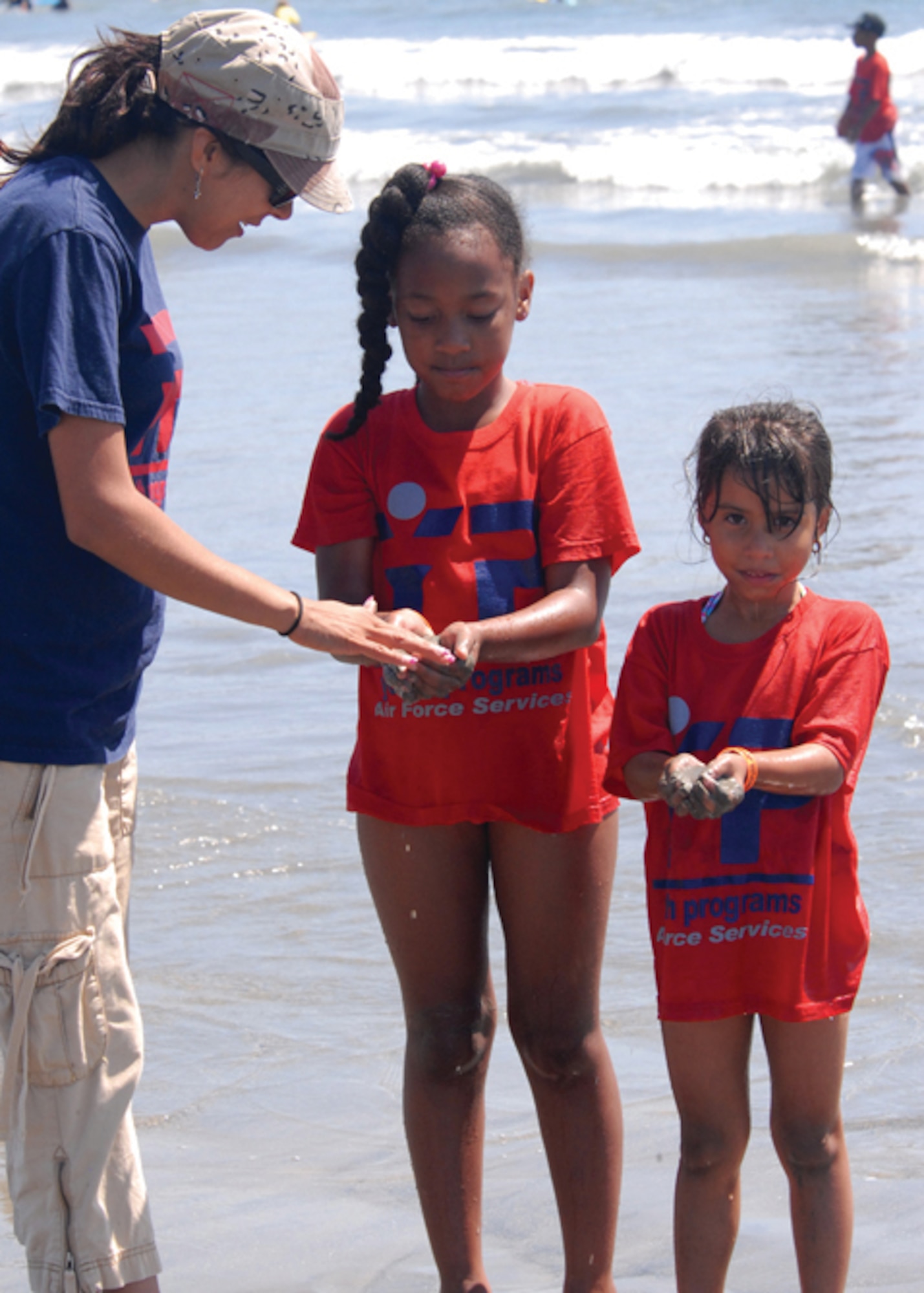 Ireland Colon (center) and Arelyz Marin (right) hold up scoops of muddy sand for Maricela McIntosh from the Youth Center to check for any “treasures” hidden in the sand during the Seal Beach outing, Aug. 27.  This was the final 2008 Youth Summer Camp event held by the Los Angeles Air Force Base Youth Center. Participants enjoyed visits to various local attractions which featured educational venues and physical activities throughout the summer. (Photo by Joe Juarez)