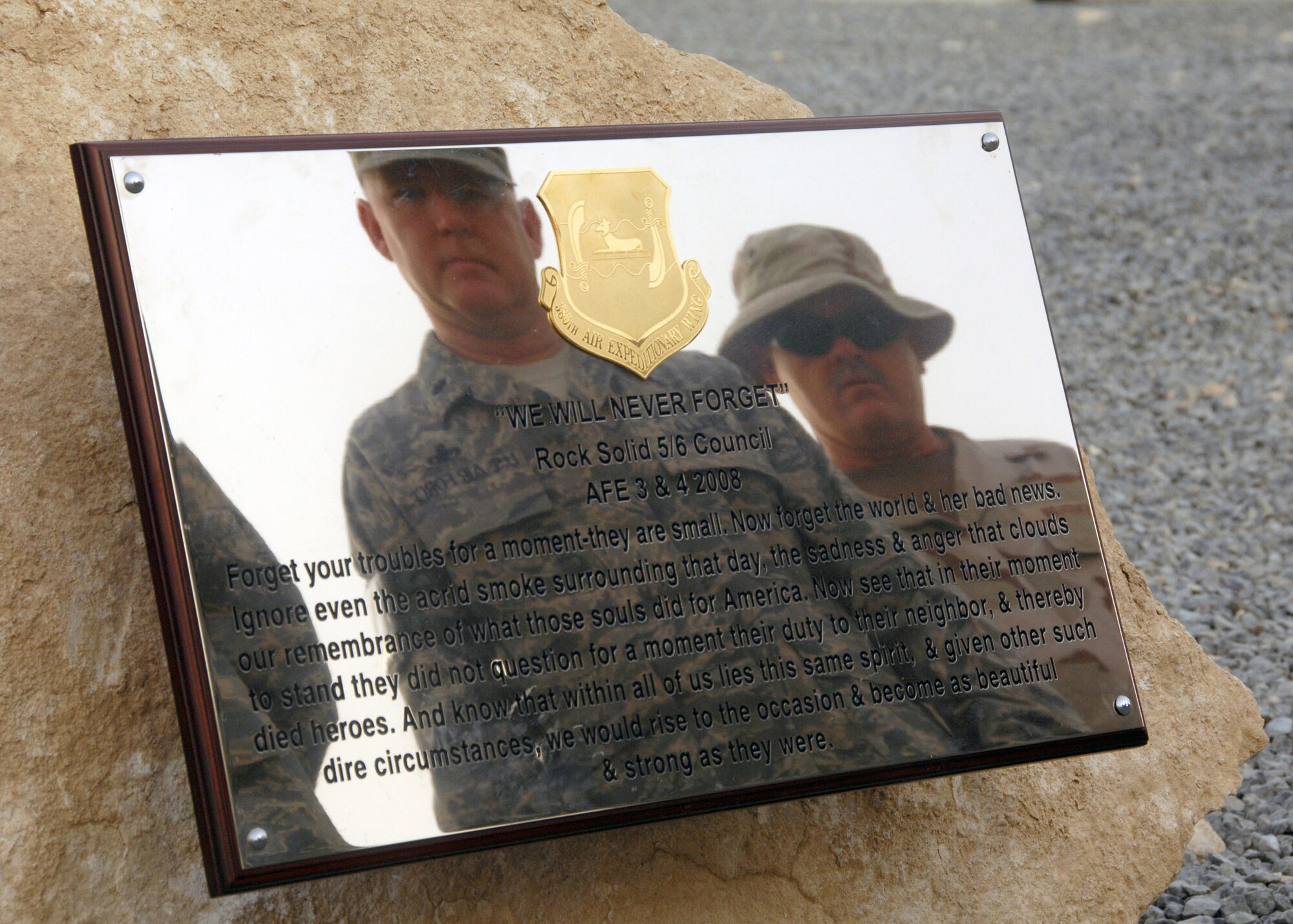 Members of the 386th Air Expeditionary Wing read the inscription on the Sept. 11 memorial plaque after the remembrance ceremony Sept. 11 at an air base in Southwest Asia. The ceremony included a wreathlaying ceremony, a 21-gun salute and the playing of "Taps" to honor the memory of those that perished and survived the terrorist attacks of Sept. 11, 2001. (U.S. Air Force photo/Tech. Sgt. Raheem Moore) 
