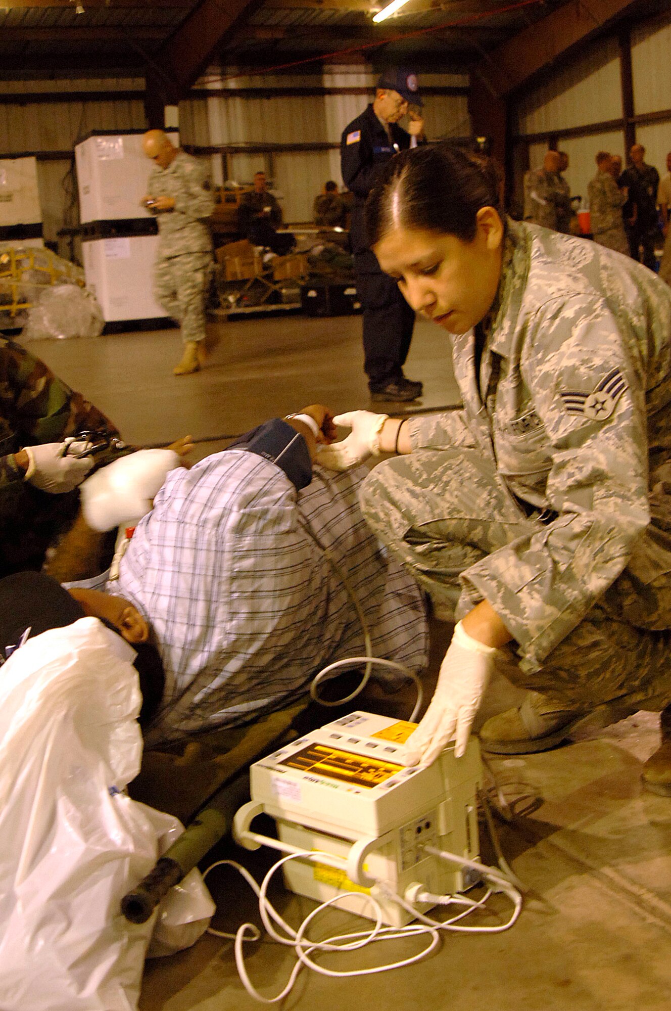 Senior Airman Andrea Moore, a medical technician with the Mobile Aeromedical Staging Facility team based out of MacDill Air Force Base, Fla.,tends to a patient waiting for evacuation in Corpus Christi, Texas, Sept. 11. The team worked late into the night helping evacuate patients from a local area hospital. U.S. Air Force aircraft transported patients to safe locations out of Hurricane Ike's path. (U.S. Air Force Photo by Staff Sgt. Robert Maki) (Released)