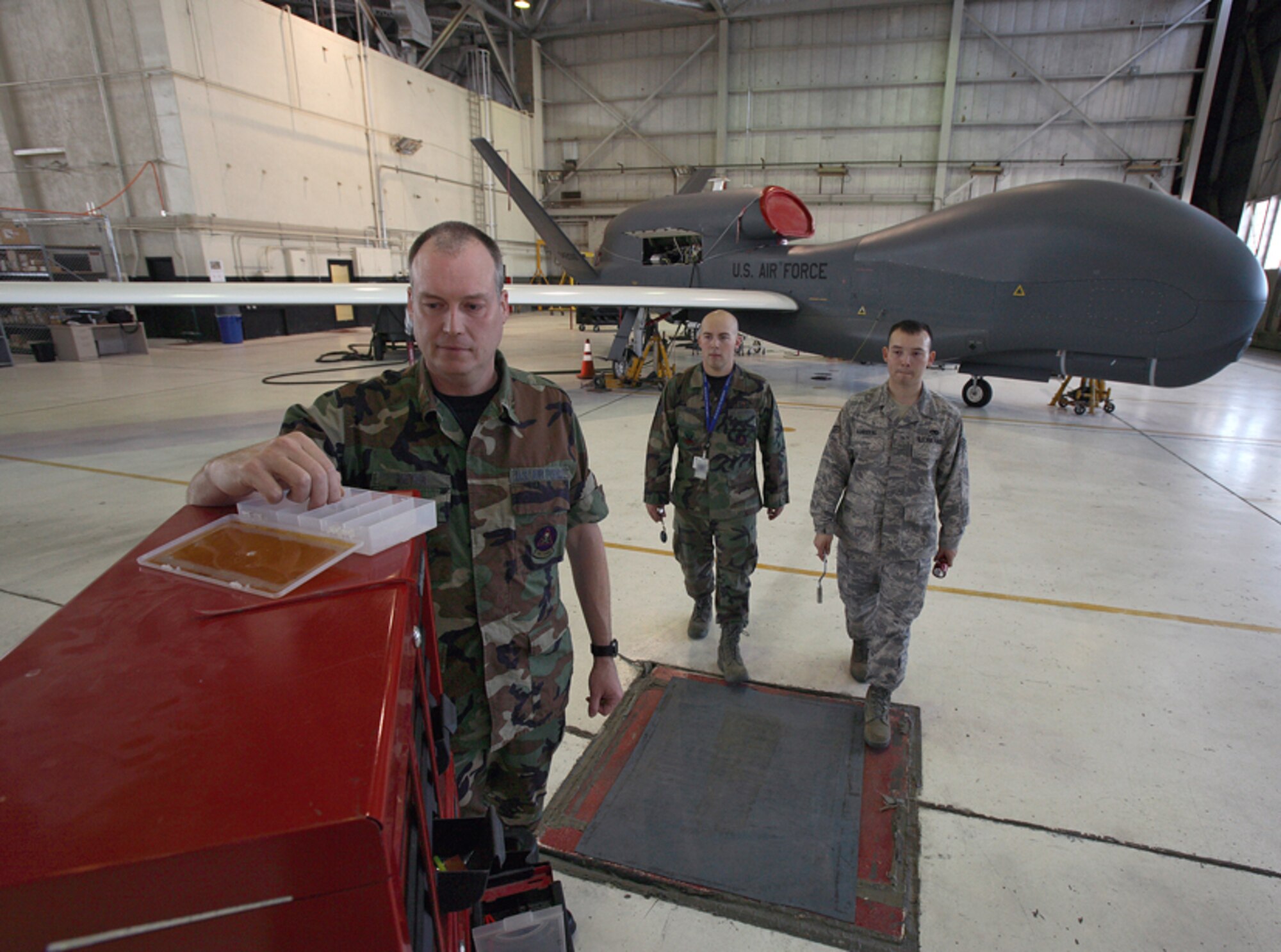 Maj. Greg Meyer assists Senior Airmen Aaron Weldon and Hector Sandoval, 31st Test and Evaluation Squadron, as they prepare for ongoing operational testing of the RQ-4 Global Hawk.  Major Meyer just won the Air Force Research and Development Award for his contributions and work with the Weighted Adaptive Iterative Statistical Threshold algorithm.  U.S. Air Force photo.