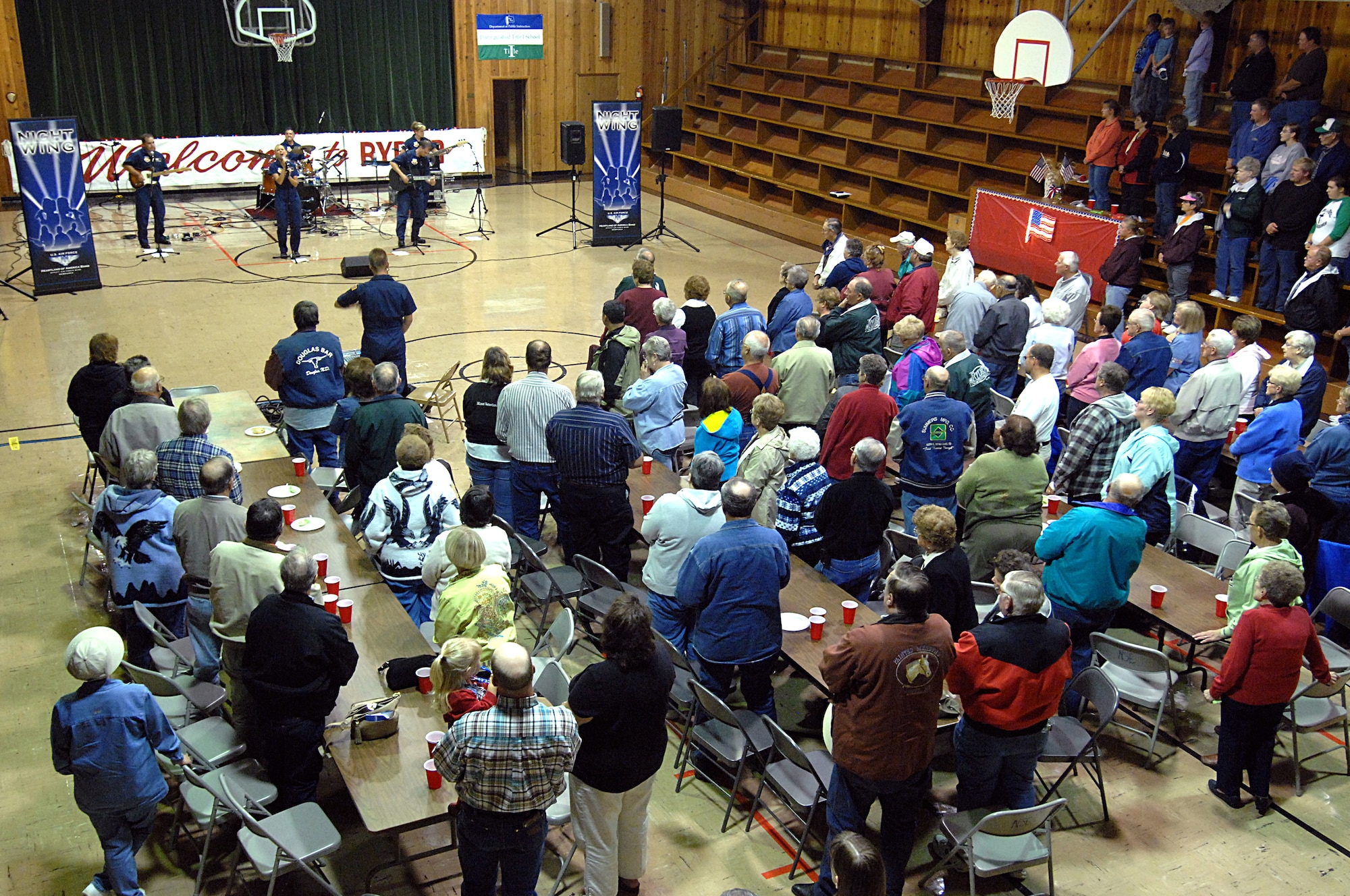 MINOT AIR FORCE BASE, N.D. -- Residents of Ryder, N.D., rise to their feet Sept. 4 during the playing of "God Bless America" by Night Wing, a popular and country music ensemble with the U.S. Air Force Heartland of America Band out of Offutt AFB, Neb. The 91st Missile Wing sponsored the performance to show its appreciation to Ryder for the residents' support of the wing's ICBM mission. Approximately 150 people attended the event, which included a "burger burn" courtesy of the 741st Missile Squadron. (U.S. Air Force photo by Senior Airman Kelly Timney)