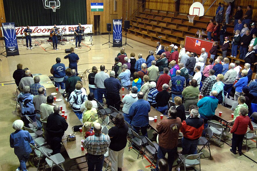 MINOT AIR FORCE BASE, N.D. -- Residents of Ryder, N.D., rise to their feet Sept. 4 during the playing of "God Bless America" by Night Wing, a popular and country music ensemble with the U.S. Air Force Heartland of America Band out of Offutt AFB, Neb. The 91st Missile Wing sponsored the performance to show its appreciation to Ryder for the residents' support of the wing's ICBM mission. Approximately 150 people attended the event, which included a "burger burn" courtesy of the 741st Missile Squadron. (U.S. Air Force photo by Senior Airman Kelly Timney)