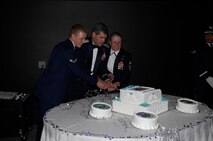 MINOT AIR FORCE BASE N.D. -- Airman 1st Class Clifton Wohlgemuth, 791st Missile Security Forces Squadron; Lt.  Gen. Daniel Darnell, deputy chief of staff for air, space and information operations, plans and requirements for Headquarters Air Force in Washington, D.C.; and Chief Master Sergeant Susan Baker, 5th Mission Support Group superintendent, cut the cake at the  Air Force's 61st birthday celebration ball here, Sept 6. It is tradition that the first cut in the cake is made by the youngest Airman and the oldest Airman in attendance, along with the guest speaker. (U.S. Air Force photo by Senior Airman Joe Rivera)