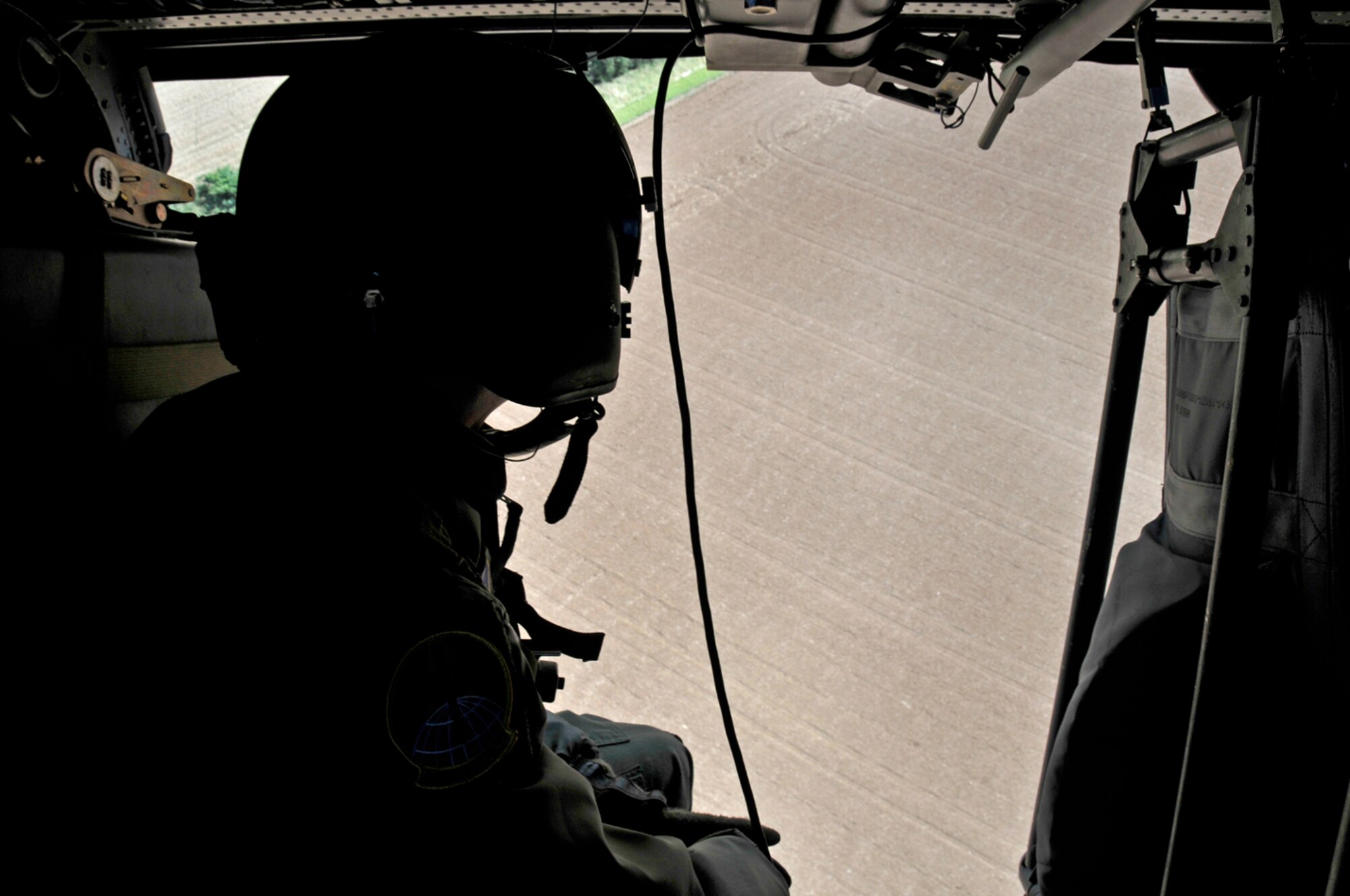 Capt. Timothy Fagen, 56th Rescue Squadron gets a good view of the farmland while the helicopter does a sharp left turn to do a flyby over the Imperial War Museum in Duxford in Duxford, England. (U.S. Air Force photo by Airman 1st Class Perry Aston)