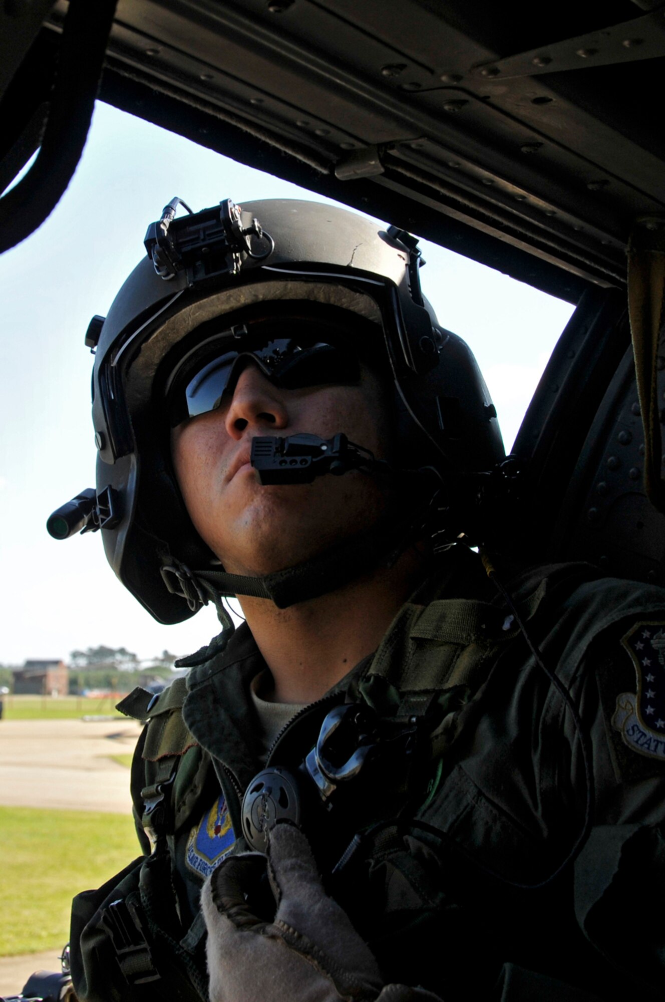 Senior Airman Charles Hippler, 56th Rescue Squadron looks out for any problems that may arise while the HH-60G Pave Hawk hovers over the flightline on RAF Lakenheath, England. The pilot hovers a few feet off the ground to ensure all equipment is working correctly before taking off. (U.S. Air Force photo by Airman 1st Class Perry Aston)
