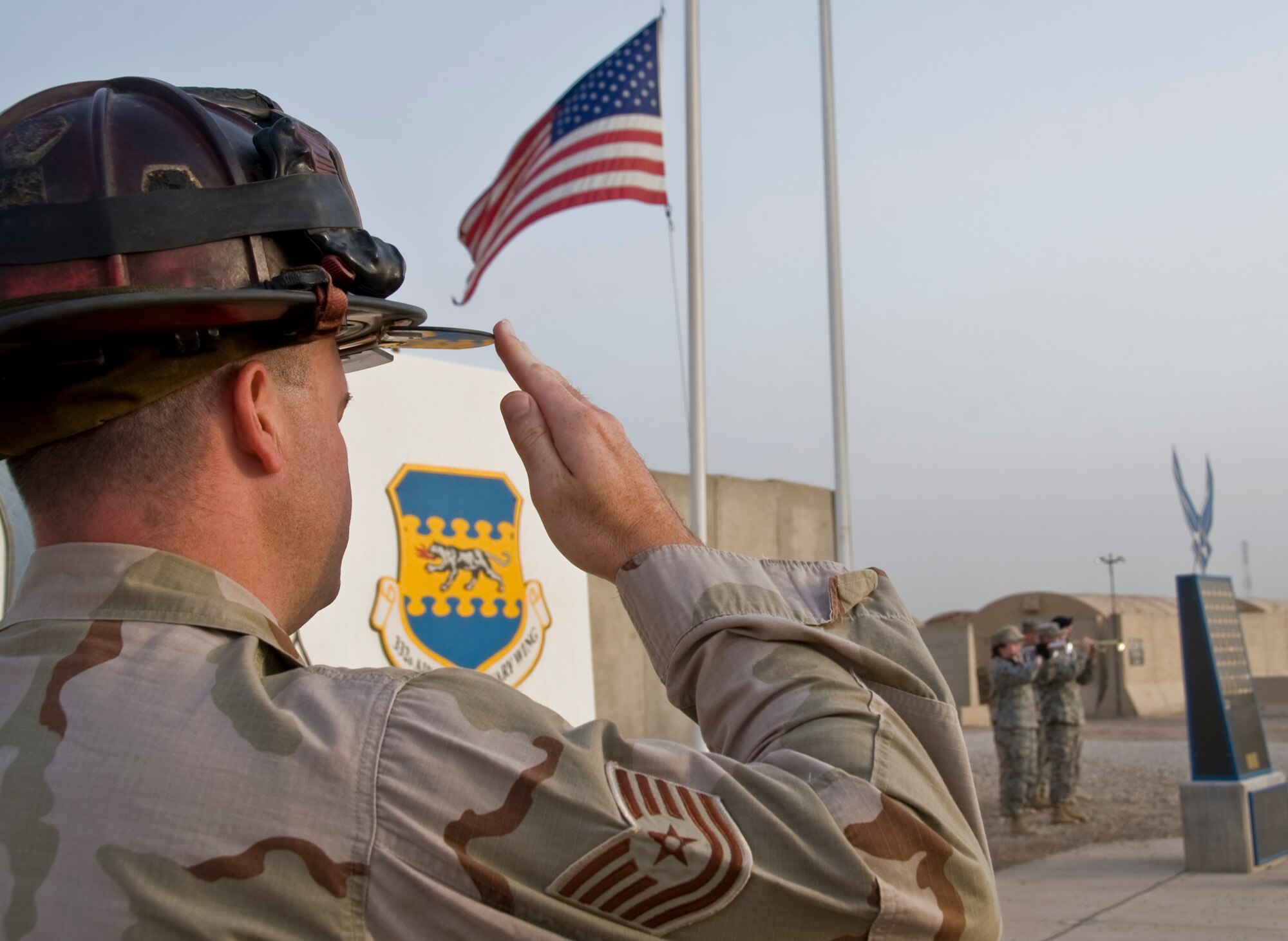 ALI BASE, Iraq -- Tech. Sgt. Michael Routh, 407th Expeditionary Civil Engineer Squadron fire fighter, salutes the United States of America's flag during a 9/11 remembrance ceremony Sept. 11, 2008. The 407th Air Expeditionary Group here held a remembrance ceremony following reveille, honoring those who had lost their lives back on this day in 2001. (U.S. Air Force photo/Airman 1st Class Christopher Griffin)
