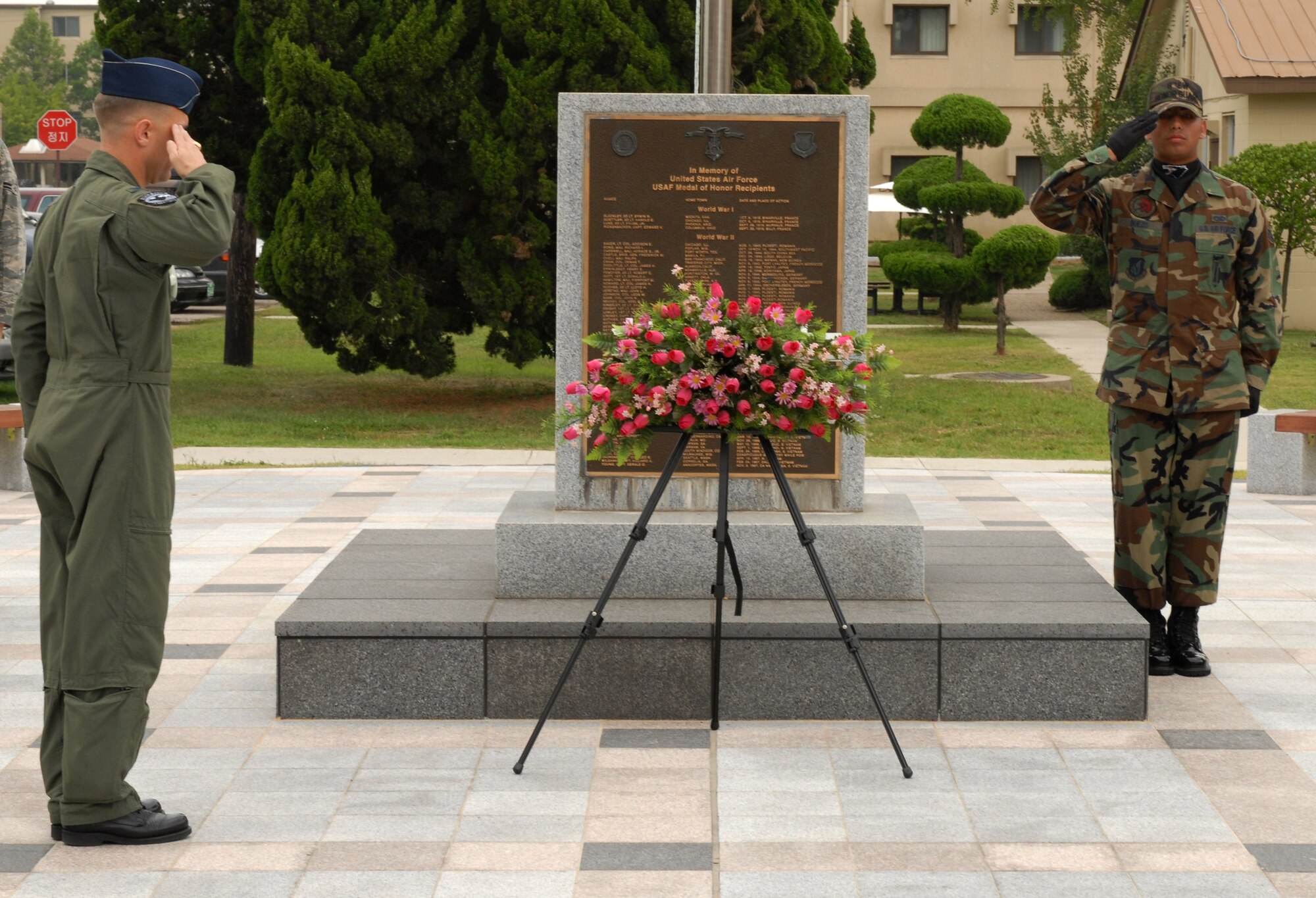 KUNSAN AIR BASE, Republic of Korea -- Col. Bryan ?WOLF? Bearden, the 8th Fighter Wing commander, and Senior Airman Luis Buezo, an 8th Fighter Wing honor guardsman, salute the flag during the 9/11 ceremony here, Sept. 11 at the base?s Medal of Honor monument. The remembrance ceremony has been held each year here to honor the fallen in the attacks Sept. 11, 2001. (U.S. Air Force photo/Senior Airman Gustavo Gonzalez)

