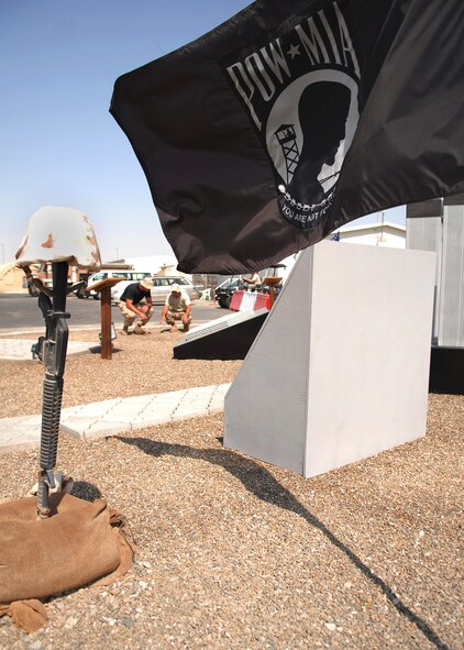 SOUTHWEST ASIA -- Senior Airman Timothy Lazarus (left) and Staff Sgt. Mitchell Robinson, both with the 380th Expeditionary Civil Engineer Fire and Emergency Services, visit the Circle of Honor here to determine the location of a new display case for the memorial. The two are part of a team who built and organized the case to house an authentic New York police officer uniform and a structural firefighting uniform. The display will be unveiled at the Patriot Day ceremony to commemorate the fallen responders from the 2001 terrorist attacks. (U.S. Air Force photo/Tech. Sgt. Denise Johnson)(released)