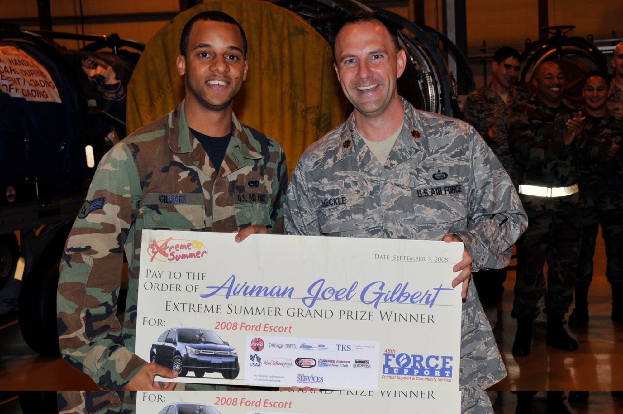 Airman 1st Class Joel Gilbert, 48th Component Maintenance Squadron and Maj. Kevin Heckle, 48th Force Support Squadron commander pose for a photo after Airman Gilbert won the Extreme Summer grand prize, a 2008 Ford Focus Sept. 5 at RAF Lakenheath, England. (U.S. Air Force photo by Airman 1st Class Perry Aston)
