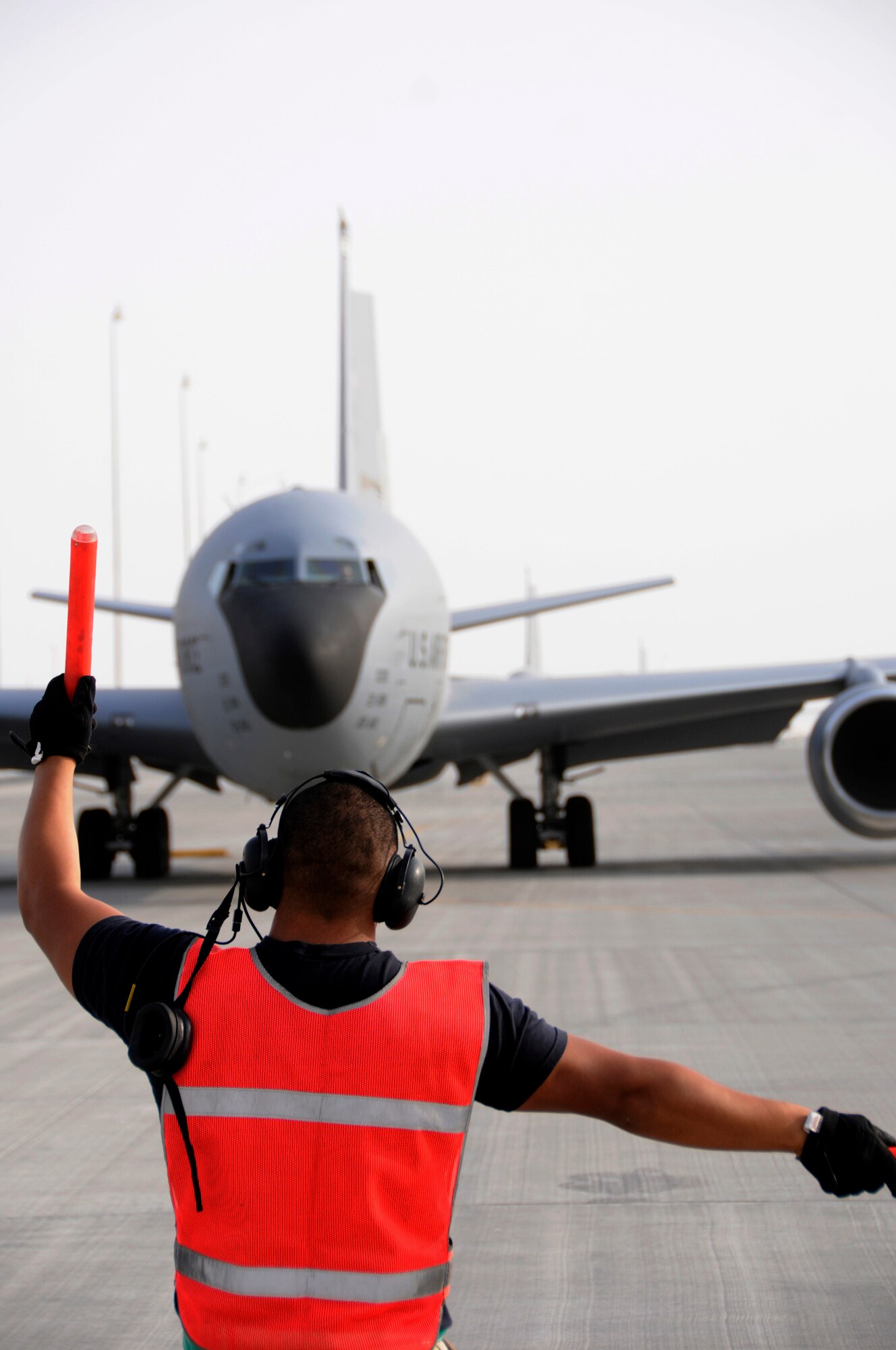 Senior Airman Michael Reyes, 379th Expeditionary Aircraft Maintenance Squadron, 340th Aircraft Maintenance Unit, signals the KC-135 Stratotanker to turn as it leaves its parking spot, taxiing off the ramp here at this undisclosed air base in Southwest Asia.  The KC-135 provides aerial refueling support to Air Force, Navy, Marine Corps and allied nation aircraft engaged in Operations Iraqi and Enduring Freedom and Joint Task Force-Horn of Africa.  Airman Reyes, a native of Temecula, Calif., is deployed from McConnell AFB, Kan. (U.S. Air Force photo by Tech. Sgt. Michael Boquette/Released)