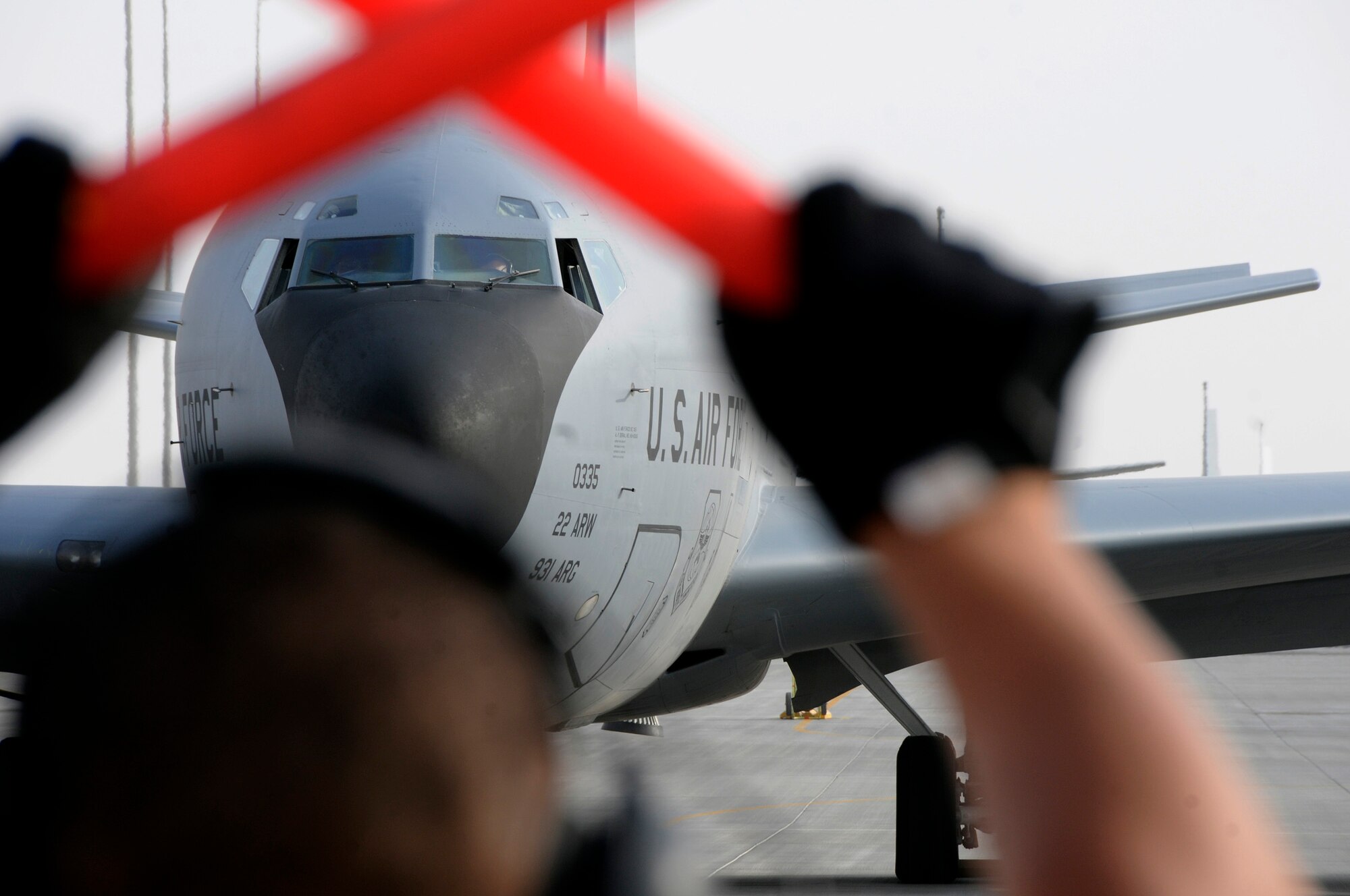 Senior Airman Michael Reyes, 379th Expeditionary Aircraft Maintenance Squadron, 340th Aircraft Maintenance Unit, signals a KC-135 Stratotanker from the 22nd Air Refueling Wing, McConnell Air Force Base, Kan., to hold prior to leaving its parking spot and taxiing off the ramp here at this undisclosed air base in Southwest Asia.  The KC-135 provides aerial refueling support to Air Force, Navy, Marine Corps and allied nation aircraft engaged in Operations Iraqi and Enduring Freedom and Joint Task Force-Horn of Africa.  Airman Reyes, a native of Temecula, Calif., is deployed from McConnell AFB, Kan. (U.S. Air Force photo by Tech. Sgt. Michael Boquette/Released)
