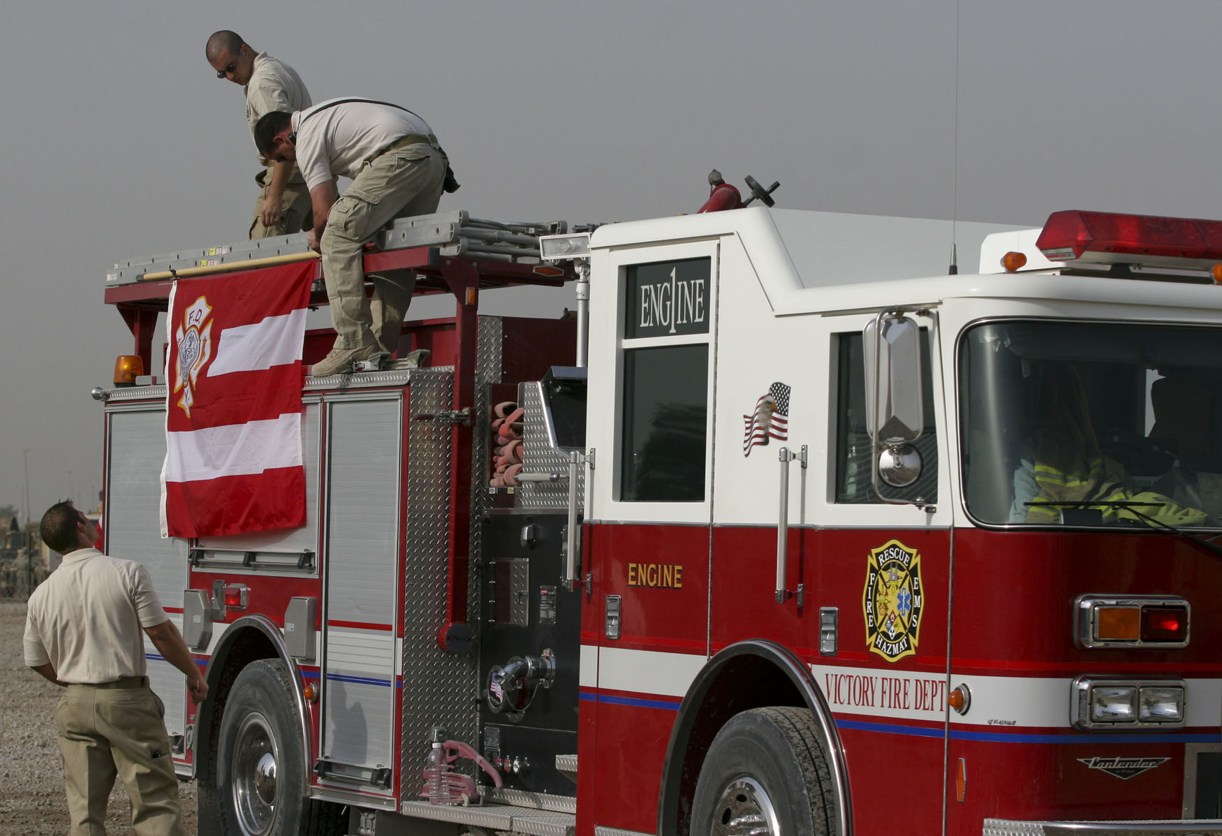 Firefighters From The Victory Base Complex Fire Department At Camp Liberty,  Iraq, Hang A New York