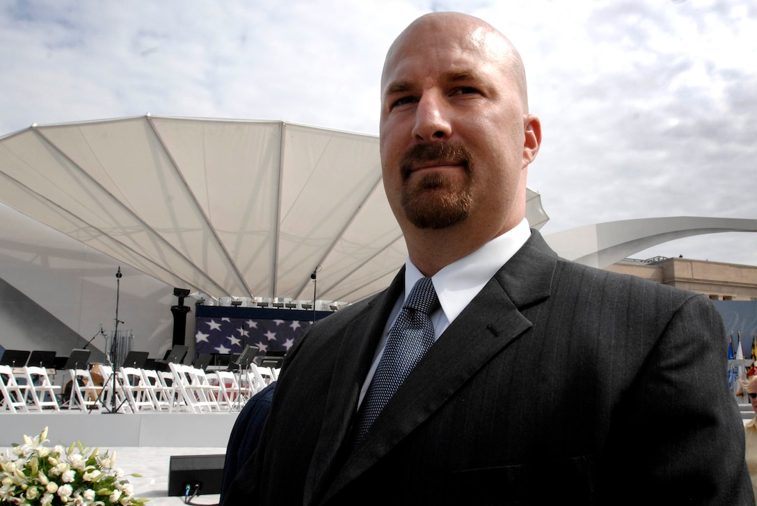 Former Army Sgt. Jeff Layne said he will always remember carrying a huge, heavy American flag up a ladder to the roof of the Pentagon. It was Sept. 12 and the symbol of Layne along with about dozen first responders unfurling the flag down the side of the building was soon a worldwide symbol of U.S. resilience. Layne and most of the original crew repeated the unfurling again today at the Pentagon 9/11 Memorial dedication ceremony. Defense Dept. photo by Fred W. Baker III