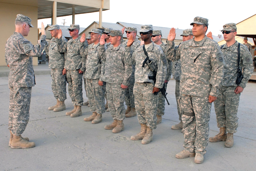 U.S. Army Colonel Brian K. Balfe, commander Combined Joint Task Force Phoenix and the 27th Infantry Brigade Combat Team leads a dozen National Guard soldiers in the oath of service as they re-enlist following the 9/11 ceremony in Patriot Square on Camp Phoenix, Afghanistan, Sept. 11, 2008. 