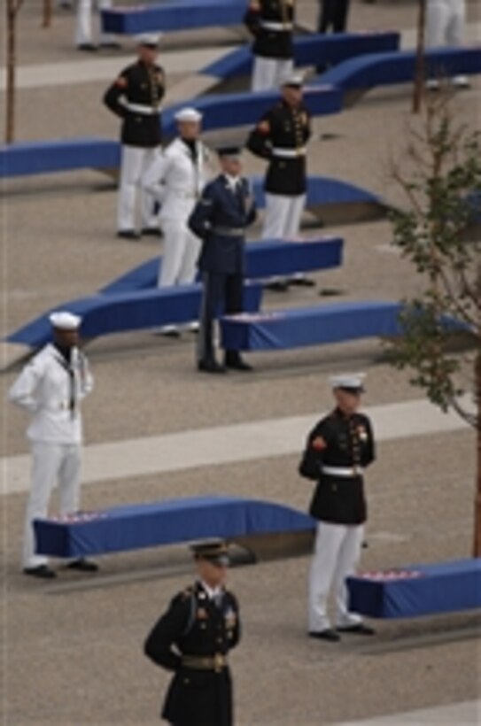 Joint service troops stand ready to unveil the Pentagon Memorial as the U.S. Air Force Band plays "Who Are the Braveî on Sept. 11, 2008.  The national memorial is the first to be dedicated to those killed at the Pentagon on Sept. 11, 2001.  The site contains 184 inscribed memorial units honoring the 59 people aboard American Airlines Flight 77 and the 125 in the building who lost their lives that day.  