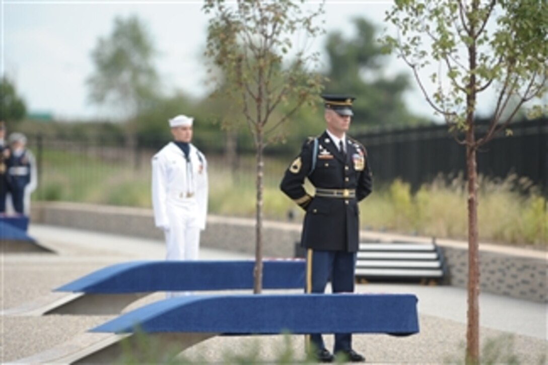 A U.S. Marine, one of one hundred eighty-four joint service troops, prepares to unveil the Pentagon Memorial on Sept. 11, 2008.  The national memorial is the first to be dedicated to those killed at the Pentagon on Sept. 11, 2001.  The site contains 184 inscribed memorial units honoring the 59 people aboard American Airlines Flight 77 and the 125 in the building who lost their lives that day.  