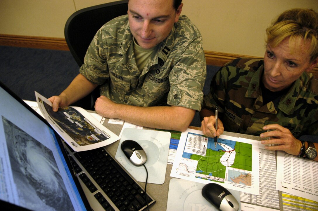 TYNDALL AIR FORCE BASE, Fla. -- Capt. John McMillen from the Air Force Weather Agency at Offutt Air Force Base, Neb., and Maj. Kimberly Pacheco, 601st Air Operations Center weather team chief, monitor the track of Hurricane Ike as they prepare for a briefing at the AOC here Sept. 11.  Weather forecasters with America’s AOC continue to work around the clock as the hurricane plows across the Gulf of Mexico toward Texas.  Captain McMillen is one of dozens of active duty members, Guardsmen and Reservists temporary assigned to the AOC and Air Forces Northern in support of hurricane relief operations.  (U.S. Air Force photo/Master Sgt. Brian S. Orban)