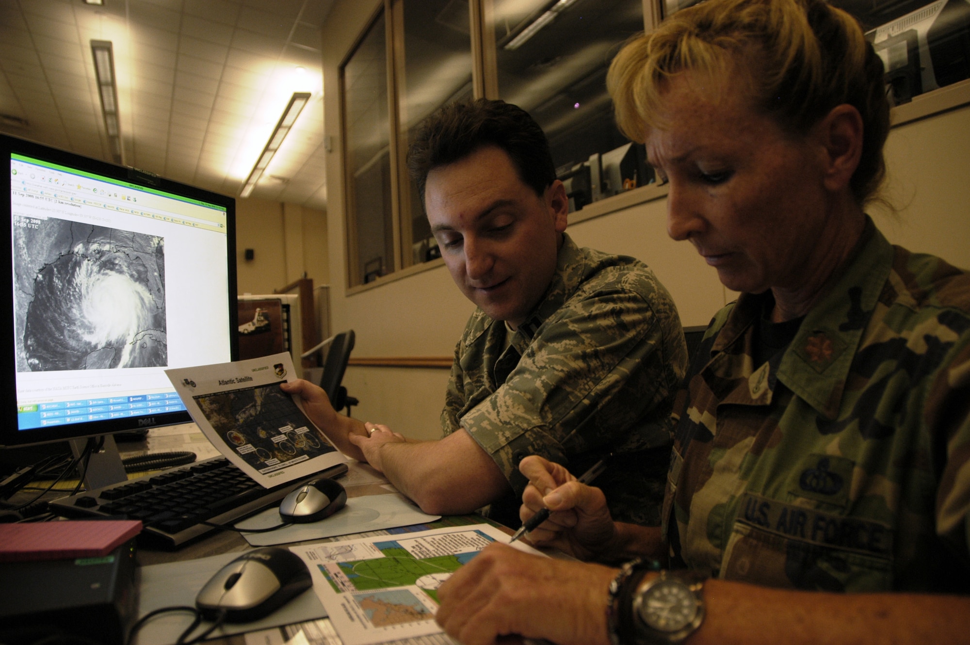 TYNDALL AIR FORCE BASE, Fla. -- Capt. John McMillen from the Air Force Weather Agency at Offutt Air Force Base, Neb., and Maj. Kimberly Pacheco, 601st Air Operations Center weather team chief, monitor the track of Hurricane Ike as they prepare for a briefing at the AOC here Sept. 11.  Weather forecasters with America’s AOC continue to work around the clock as the hurricane plows across the Gulf of Mexico toward Texas.  Captain McMillen is one of dozens of active duty members, Guardsmen and Reservists temporary assigned to the AOC and Air Forces Northern in support of hurricane relief operations.  (U.S. Air Force photo/Master Sgt. Brian S. Orban)