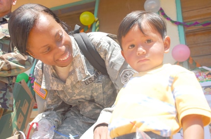 SOTO CANO AIR BASE, Honduras. Army Staff Sgt. Jenise Harris, Joint Task Force-Bravo Civil Affairs, spends time with child during Children's Day Sept. 10 in Guajiquiro, Honduras. More than 400 children in two towns spent time with servicemembers from JTF-Bravo. (U.S. Air Force photo by Staff Sgt. Joel Mease)