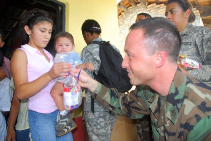 SOTO CANO AIR BASE, Honduras - Navy Petty Officer 1st Class Norm Oehring, Joint Task Force-Bravo chaplain?s assistant, gives our candy during Children's Day Sept. 10 in Siguatepeque, Honduras. More than 400 children in two towns spent time with servicemembers from JTF-Bravo. (U.S. Air Force photo by Staff Sgt. Joel Mease)