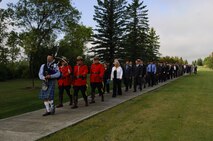 MINOT AIR FORCE BASE, N.D. - Led by a bagpiper and the Royal Canadian Mounted Police, a group of Americans and Canadians, including almost 20 Airmen and spouses from Minot AFB, proceed to the 9/11 Memorial at the International Peace Garden in Dunseith, N.D., for a remembrance service Sept. 11. Approximately 400 people from the base, surrounding North Dakota communities, and Canada gathered to pay tribute to the thousands of men and women who were tragically killed in the terrorist attacks of Sept. 11, 2001. (U.S. Air Force photo by Senior Airman Cassandra Jones)
