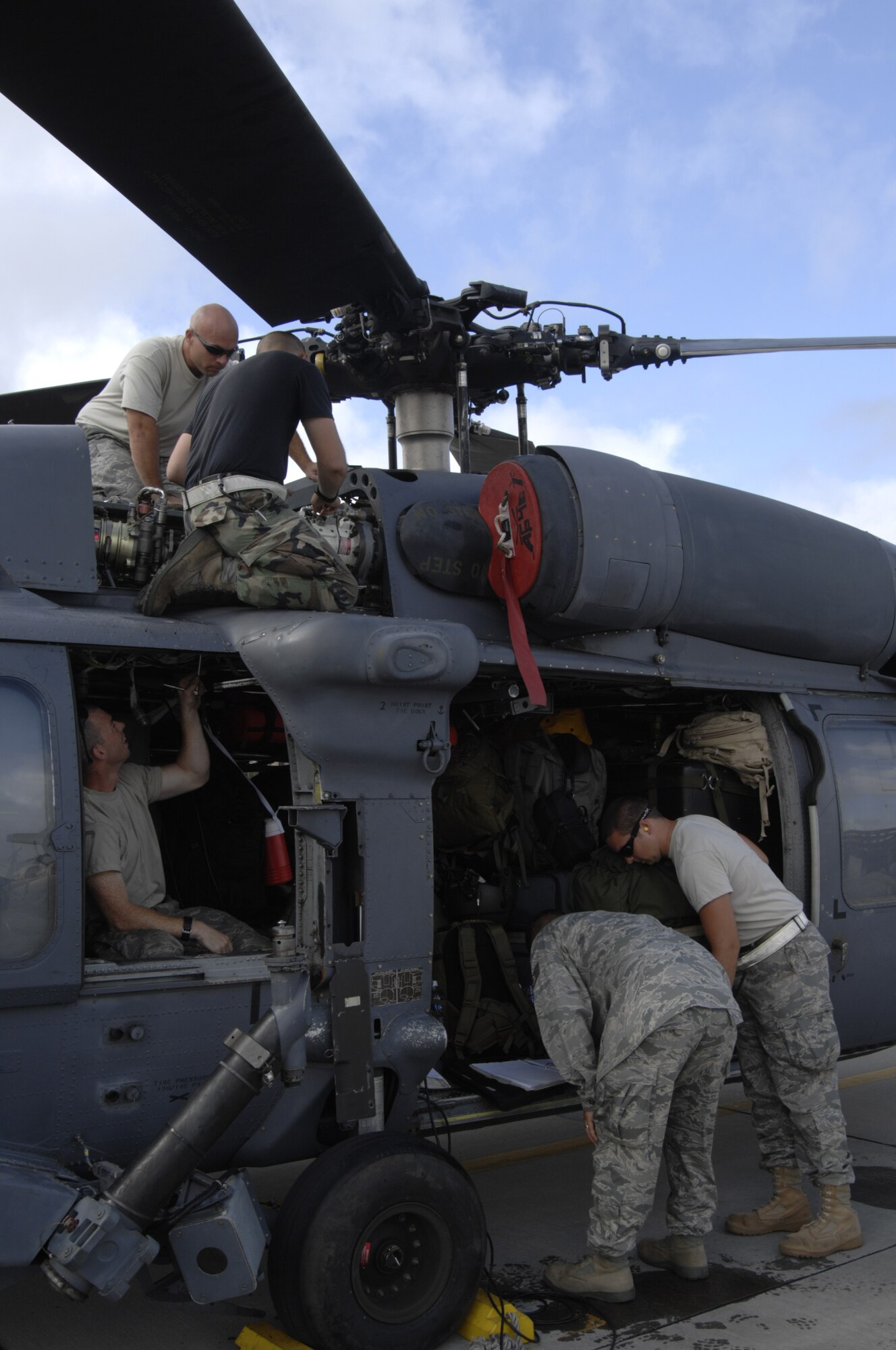 MOODY AIR FORCE BASE, Ga. -- Airmen of the 723rd Aircraft Maintenance Squadron and 41st Rescue Squadron surround a malfunctioning HH-60G Pave Hawk to diagnose and repair the problem here Sept. 12. The Airmen fix the aircraft and get the formation of HH-60's back on the runway for take off to support efforts in response to Hurricane Ike. (U.S. Air Force Photo by Senior Airman Javier Cruz)
