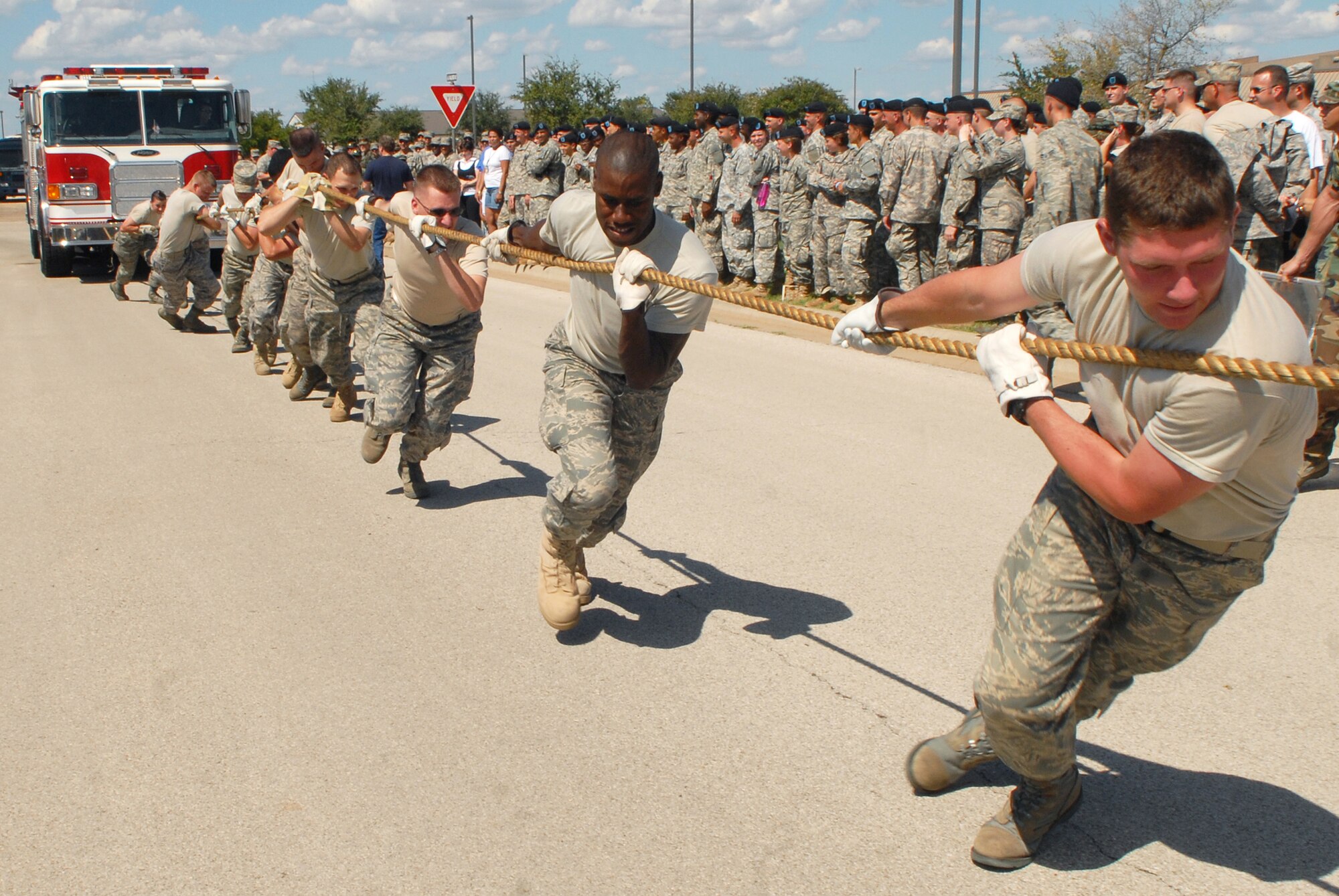 Members of the 316th Training Squadron team "Super Sweet" work together to pull a 14.5 ton fire truck 100 feet during a Combined Federal Campaign fundraiser on Goodfellow Air Force Base Sept. 5. A total of 31 teams competed in the event. (U.S. Air Force photo by Senior Airman Kasabyan Musal)