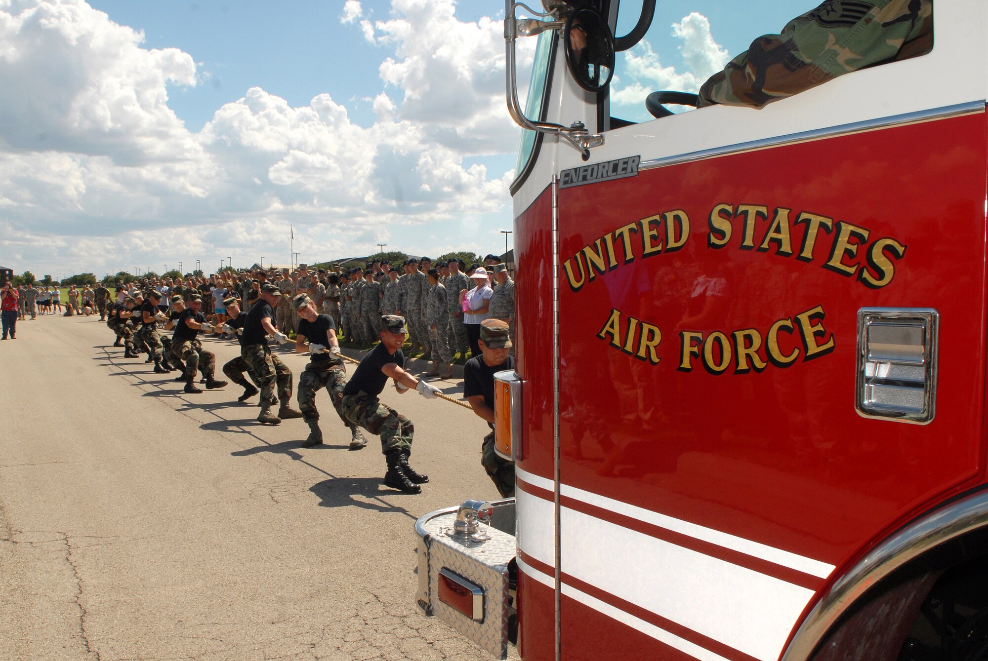 Members of the 316th Training Squadron team "Snow White and the 11 Dwarfs"  work together to pull a 14.5 ton fire truck 100 feet during a Combined Federal Campaign fundraiser on Goodfellow Air Force Base Sept. 5. A total of 31 teams competed in the event. (U.S. Air Force photo by Senior Airman Kasabyan Musal)