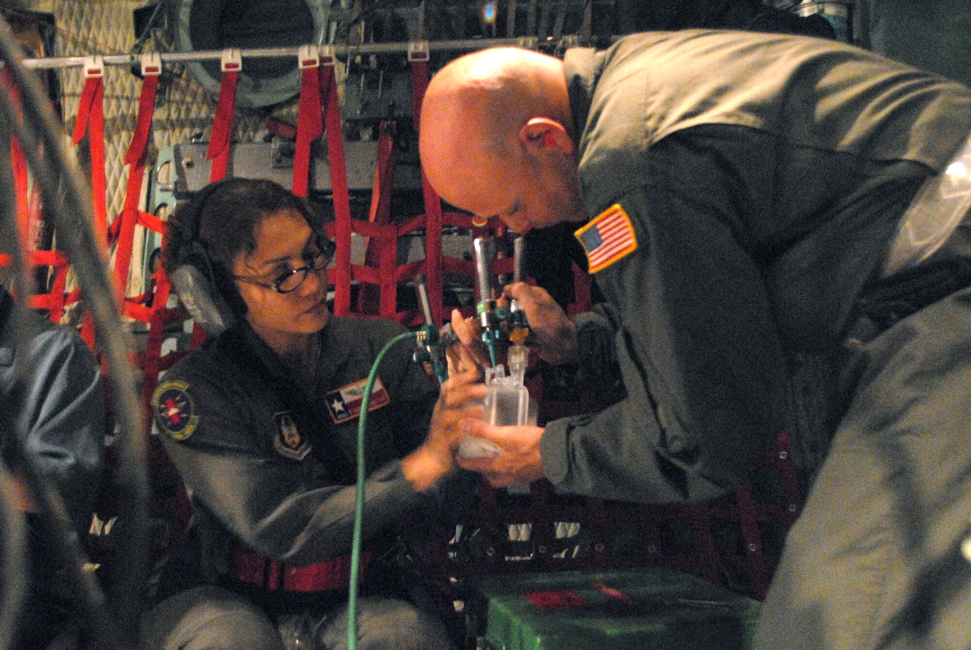 CORPUS CHRISTI INTERNATIONAL AIRPORT, Texas -- Senior Master Sgt. Rowena Sanchez-Reitan and Master Sgt. Mark Juarez, air evacuation tecnicians of the 4th Air Force Reserve Command, 433rd Air Evacuation Squadron, assemble an oxygen system on a C-130E aircraft, September 11, 2008. Little Rock Air Force Base C-130 aircraft and crews are tasked routinely to evacuate possible natural disaster victims to safer locations. (U.S. Air Force photo by Airman 1st Class Steele Briton) (RELEASED)