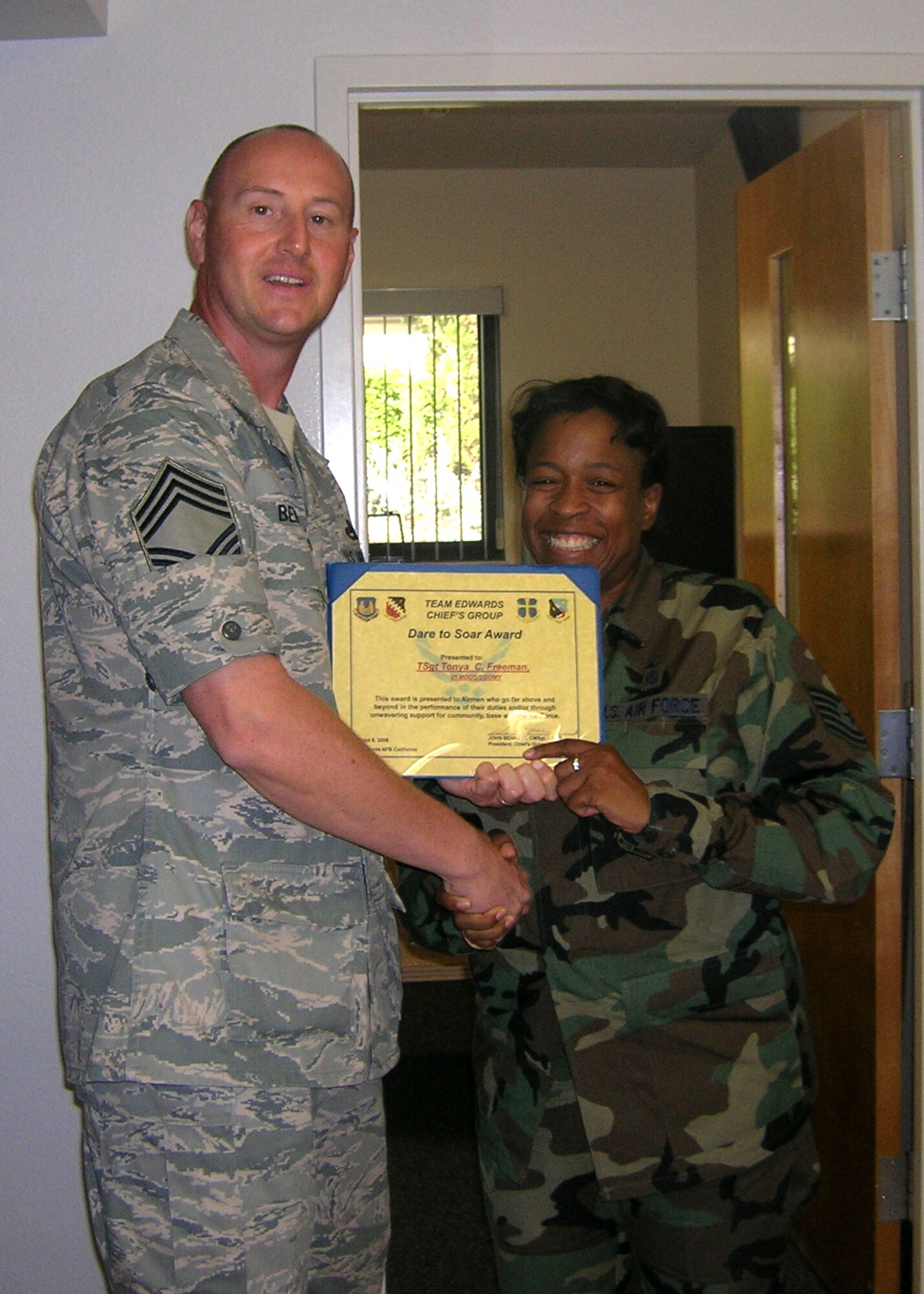 Tech. Sgt. Tonya Freeman (right), 95th Medical Operations Squadron noncommissioned officer in charge, received the Dare to Soar Award Sept. 4 from Chief Master Sgt. John Bennett (left), 412th Maintenance Group weapons manager. Sergeant Freeman received the award for her patient care and efforts towards professional enhancement of medical group personnel assigned beneath her. The Dare to Soar Award is presented by the Chiefs Group to Airmen who go above and beyond in the performance of their duties. (Air Force photo by Senior Master Sgt. Rebecca Raymond)